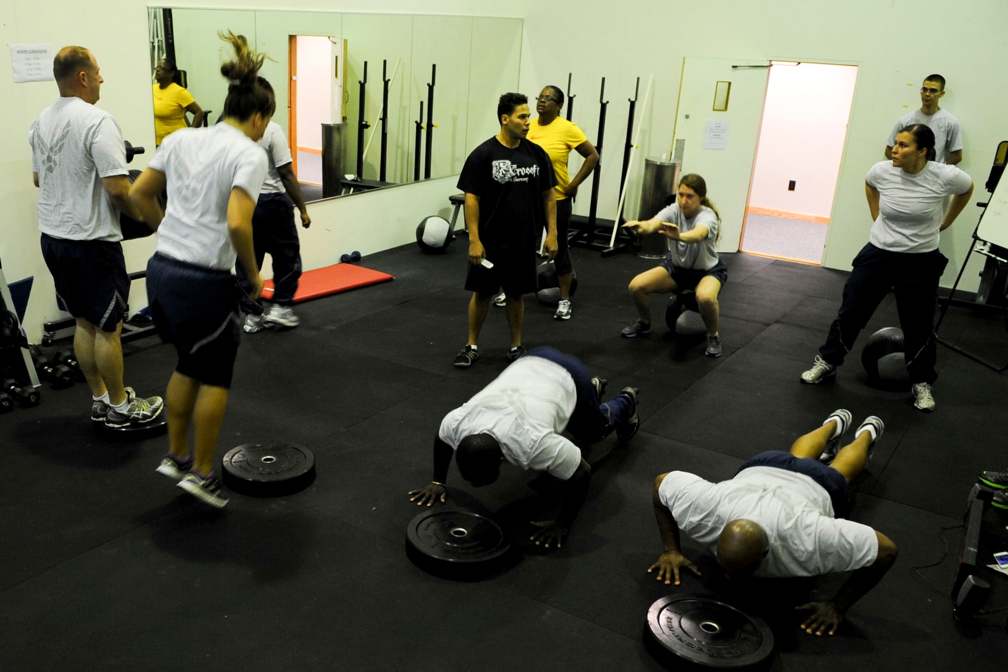 Airmen from the 633rd Force Support Squadron perform Crossfit exercises during their unit physical fitness session at the Langley Air Force Base, Va., Air Combat Command gym, May 15, 2012. Crossfit is a full-body workout meant to increase both physical and physiological tolerance. (U.S. Air Force photo by Senior Airman Wesley Farnsworth/Released)