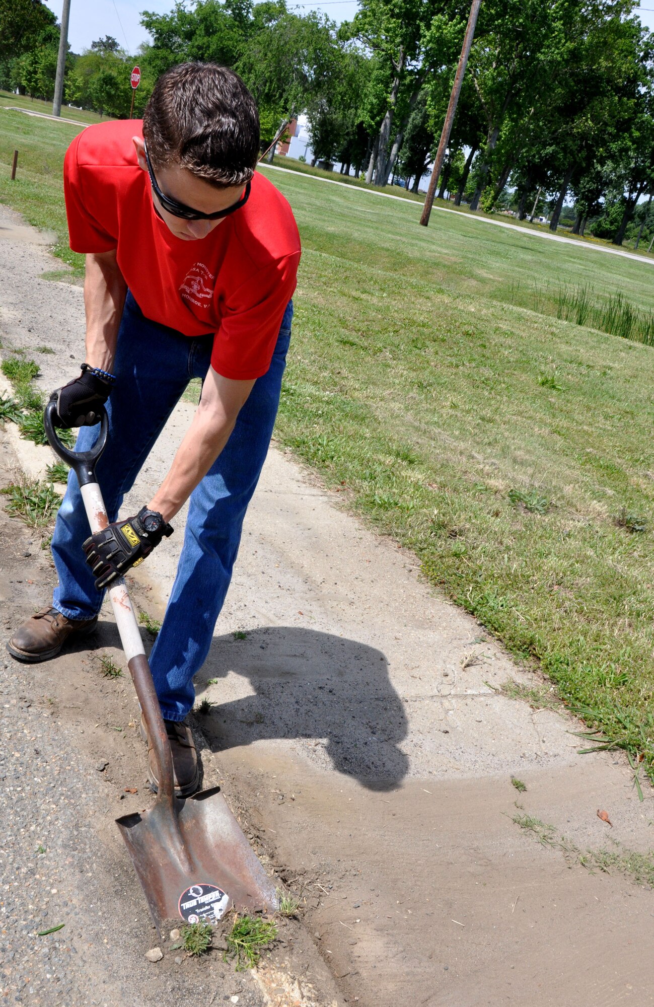 Charles Toplikar Jr., a Boy Scouts of America Troop 31 boy scout, removes weeds from an overgrown portion of the Air Combat Command running trail May 12. Troop 31 not only cleaned up, but also placed signs to mark the 6.8-mile trail that runs the circumference of Langley Air Force Base, Va., For more avid runners, Toplikar placed a turnaround point at the 4.25 mile marker. (U.S. Air Force photo by Airman 1st Class Austin Harvill/Released) 
