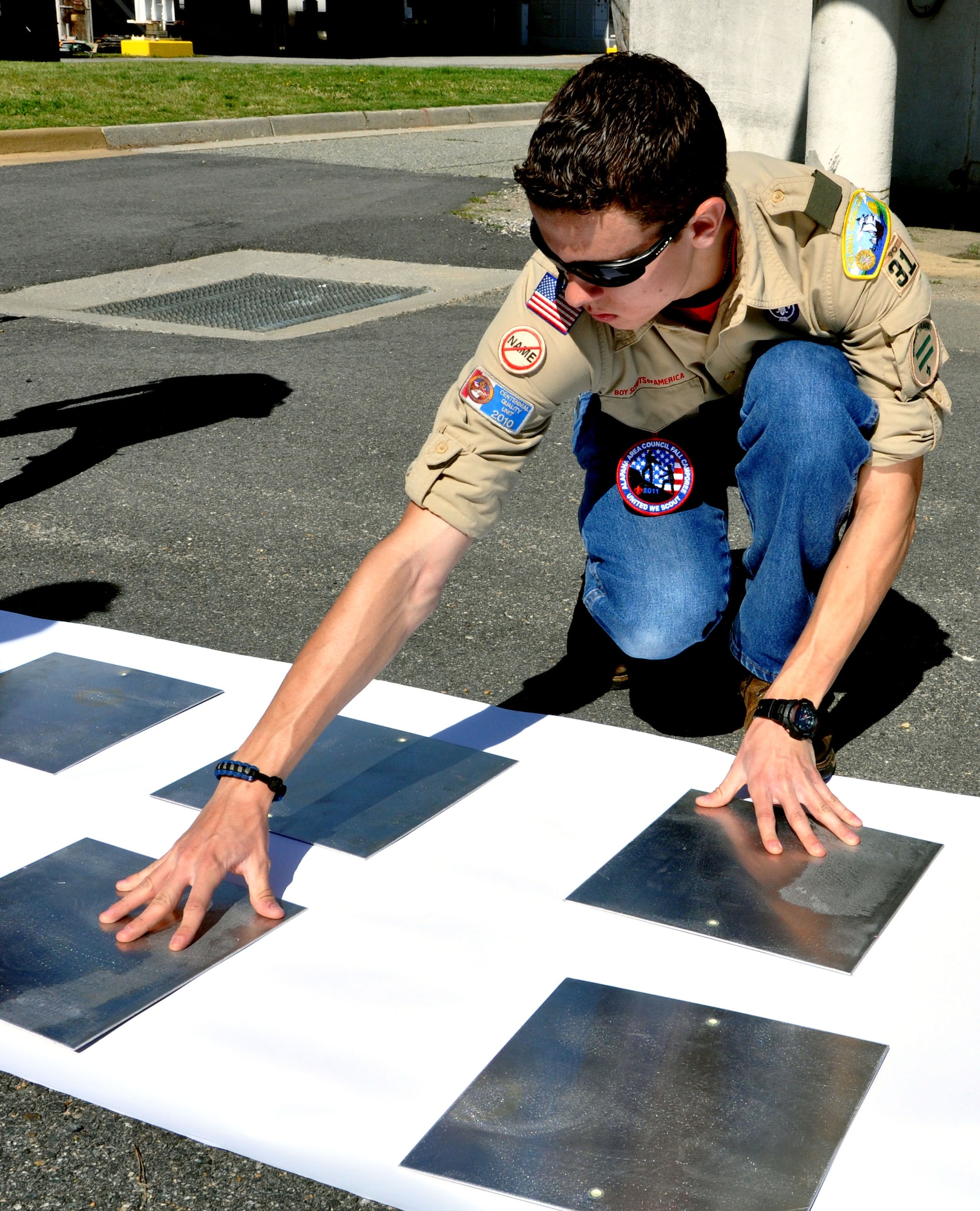 Charles Toplikar Jr., a Boy Scouts of America Troop 31 boy scout, spaces out signs to be painted May 12. Toplikar aspires to be an eagle scout, and must complete a community project to be eligible. The signs, courtesy of the 633rd Civil Engineers Squadron, display mile markers and directional arrows for the Air Combat Command running trail on Langley Air Force Base, Va.. (U.S. Air Force photo by Airman 1st Class Austin Harvill/Released) 