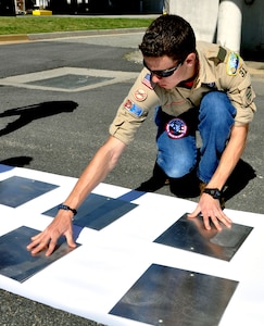 Charles Toplikar Jr., a Boy Scouts of America Troop 31 boy scout, spaces out signs to be painted May 12. Toplikar aspires to be an eagle scout, and must complete a community project to be eligible. The signs, courtesy of the 633rd Civil Engineers Squadron, display mile markers and directional arrows for the Air Combat Command running trail on Langley Air Force Base, Va.. (U.S. Air Force photo by Airman 1st Class Austin Harvill/Released) 