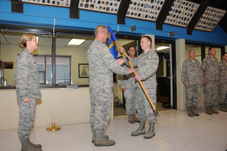 SIOUX FALLS, S.D. - Col. Joel DeGroot, 114th Maintenance Group commander, passes the 114th Maintenance Squadron flag to Maj. Scott Rust, the new 114th Maintenance Squadron commander here May 5, 2012. The position is staying in the family as Maj. Rust is replacing his sister, Lt. Col. Kristin Baur, as the new Maintenance Squadron commander. (National Guard photo by Tech. Sgt. Quinton Young)(Released)