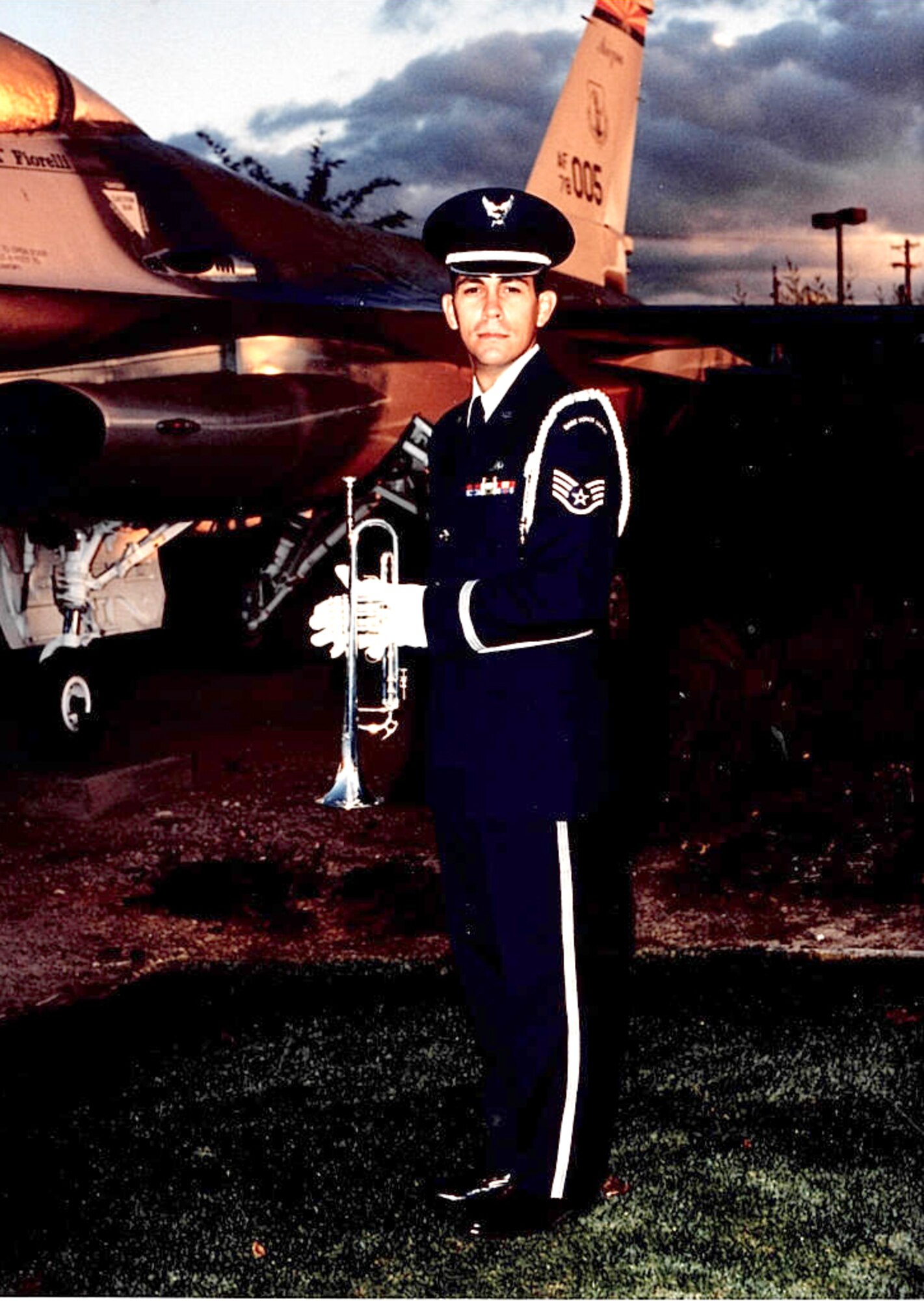 Tech. Sgt. Michael Brizuela, a staff sergeant in 1995, takes a photo with his bugle and an F-16 Fighting Falcon at Tucson International Airport. The aircraft maintenance specialist has volunteered countless hours to performing Honor Guard duty over the last 30 years. (Courtesy photo)