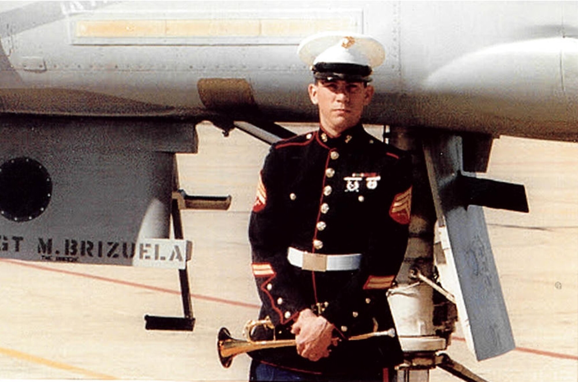 U.S. Marine Corp Sgt. Michael Brizuela takes a photo with his bugle and his F-4 Phantom at Naval Air Station Dallas in 1988. For 30 years he has volunteered with Marine and Air Guard Honor Guards. (Courtesy photo)