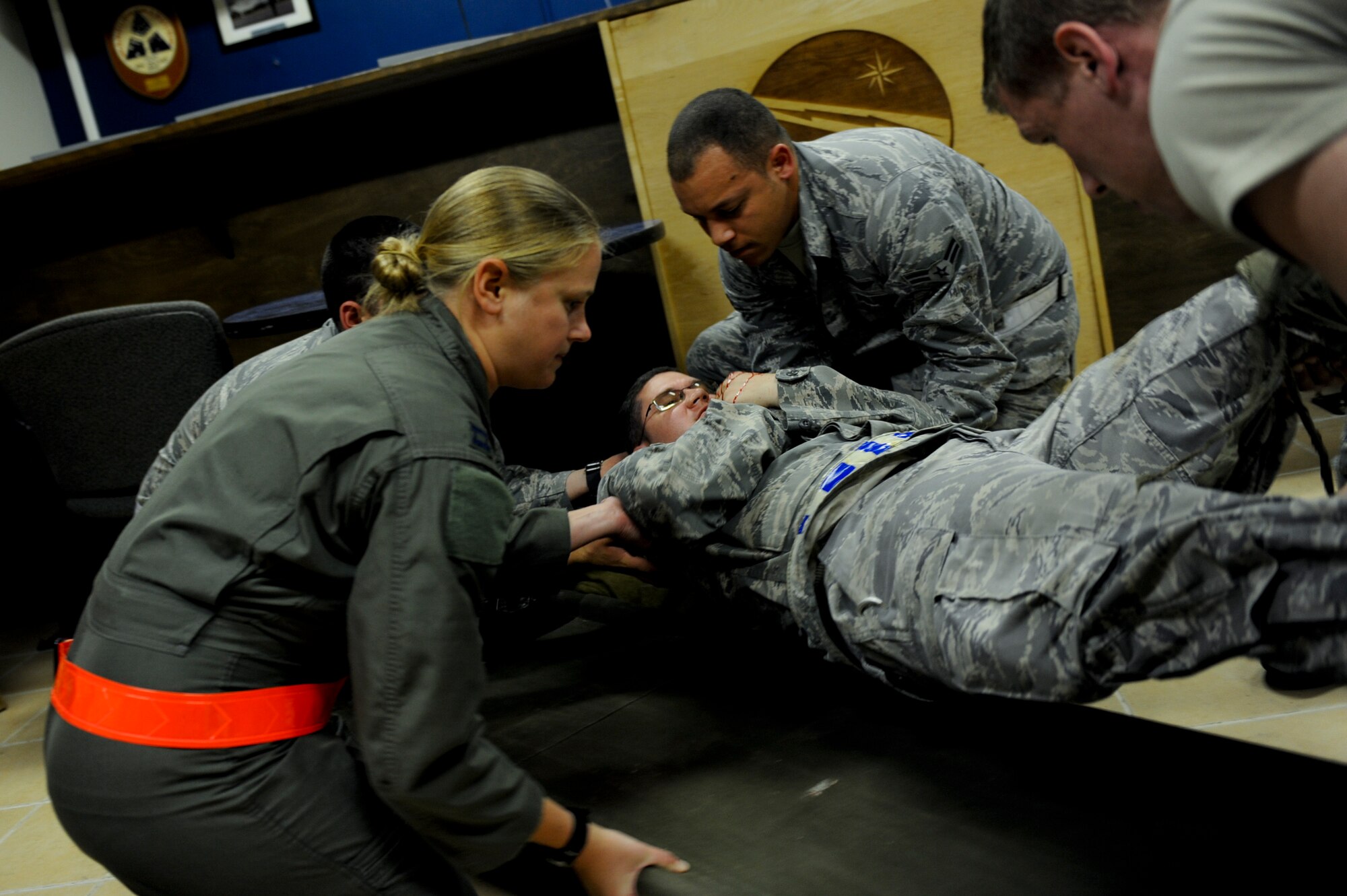 Airmen from the 961st Airborne Air Control Squadron move U.S. Air Force Staff Sgt. Sean Lucas, 18th Air Maintenance Squadron jet engine journeyman, onto a stretcher after stabilizing him during a self-aid and buddy care training scenario during local operational readiness exercise Beverly High 12-4 on Kadena Air Base, Japan, May 15, 2012. Kadena Airmen were evaluated this week on their readiness to mobilize, deploy, and regenerate personnel, cargo and aircraft. (U.S. Air Force photo/Airman 1st Class Brooke P. Beers)