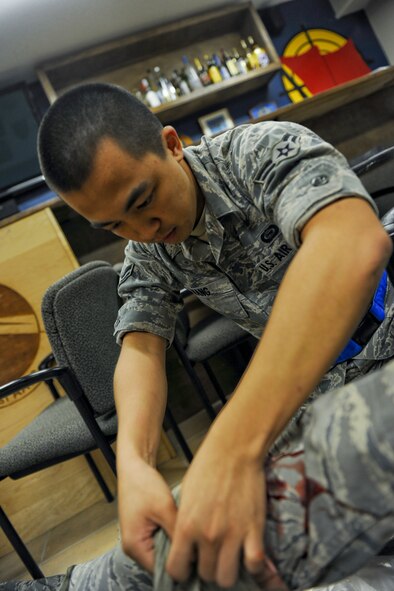 U.S. Air Force Airman 1st Class Jason Wang, 18th Operations Support Squadron intelligence analyst, applies a tourniquet to a fellow Airman during a self-aid and buddy care scenario during local operational readiness exercise Beverly High 12-4 on Kadena Air Base, Japan, May 15, 2012. LOREs are conducted on a regular basis to test the base's ability to defend Japan and maintain peace and stability in the Pacific region. (U.S. Air Force photo/Airman 1st Class Brooke P. Beers)