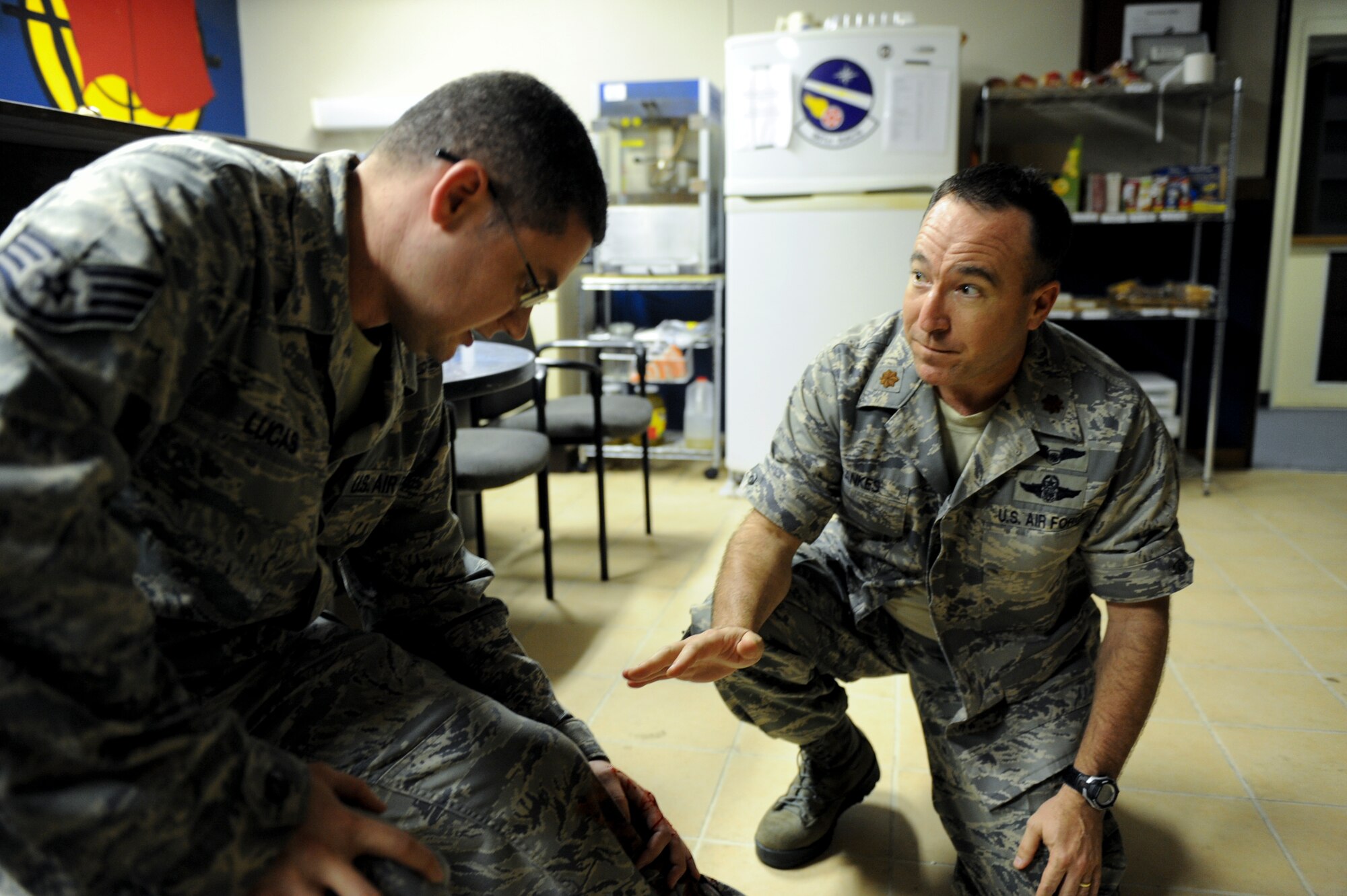 U.S. Air Force Maj. Paul Lankes, 961st Airborne Air Control Squadron, assists U.S. Air Force Staff Sgt. Sean Lucas, 18th Aircraft Maintenance Squadron jet engine journeyman, during a self-aid and buddy care scenario during local operational readiness exercise Beverly High 12-4 on Kadena Air Base, Japan, May 15, 2012. The training scenario provided the Airmen of the 961st AACS the opportunity to train on self-aid and buddy care to prepare themselves for possible future real-world contingencies. (U.S. Air Force photo/Airman 1st Class Brooke P. Beers)