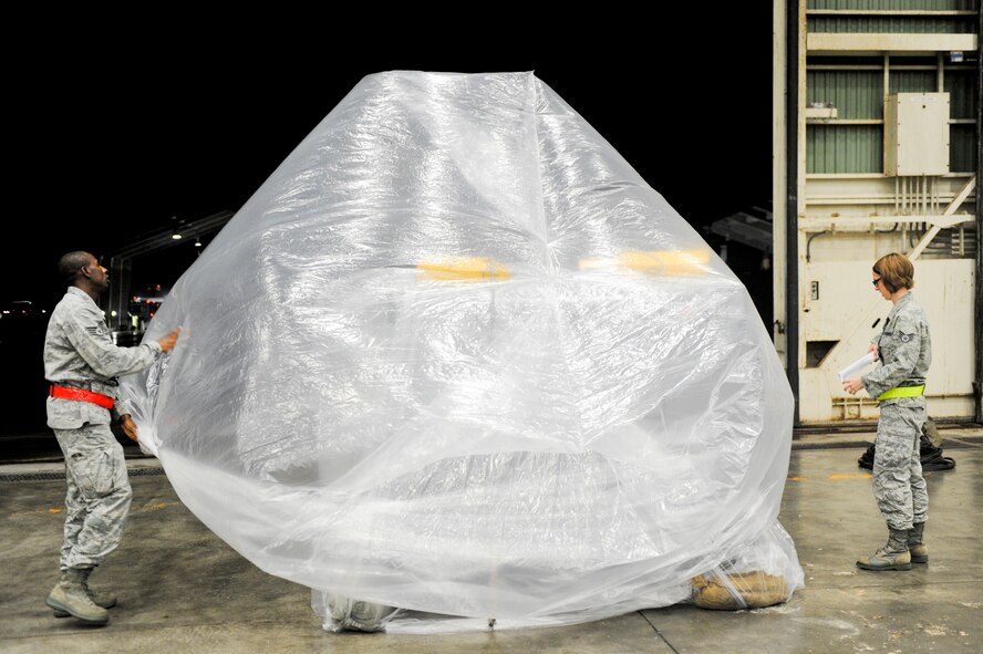 U.S. Air Force Staff Sgt. Conray Brown and U.S. Air Force Staff Sgt. Hilary Waite, 18th Maintenance Operations Squadron, participate in a training scenario that tests their ability to wrap assets in a chemical environment during local operational readiness exercise Beverly High 12-4 on Kadena Air Base, Japan, May 15, 2012. The LORE is designed to train Kadena’s Airmen to survive and operate under various conditions. (U.S. Air Force photo/Airman 1st Class Hailey R. Davis)