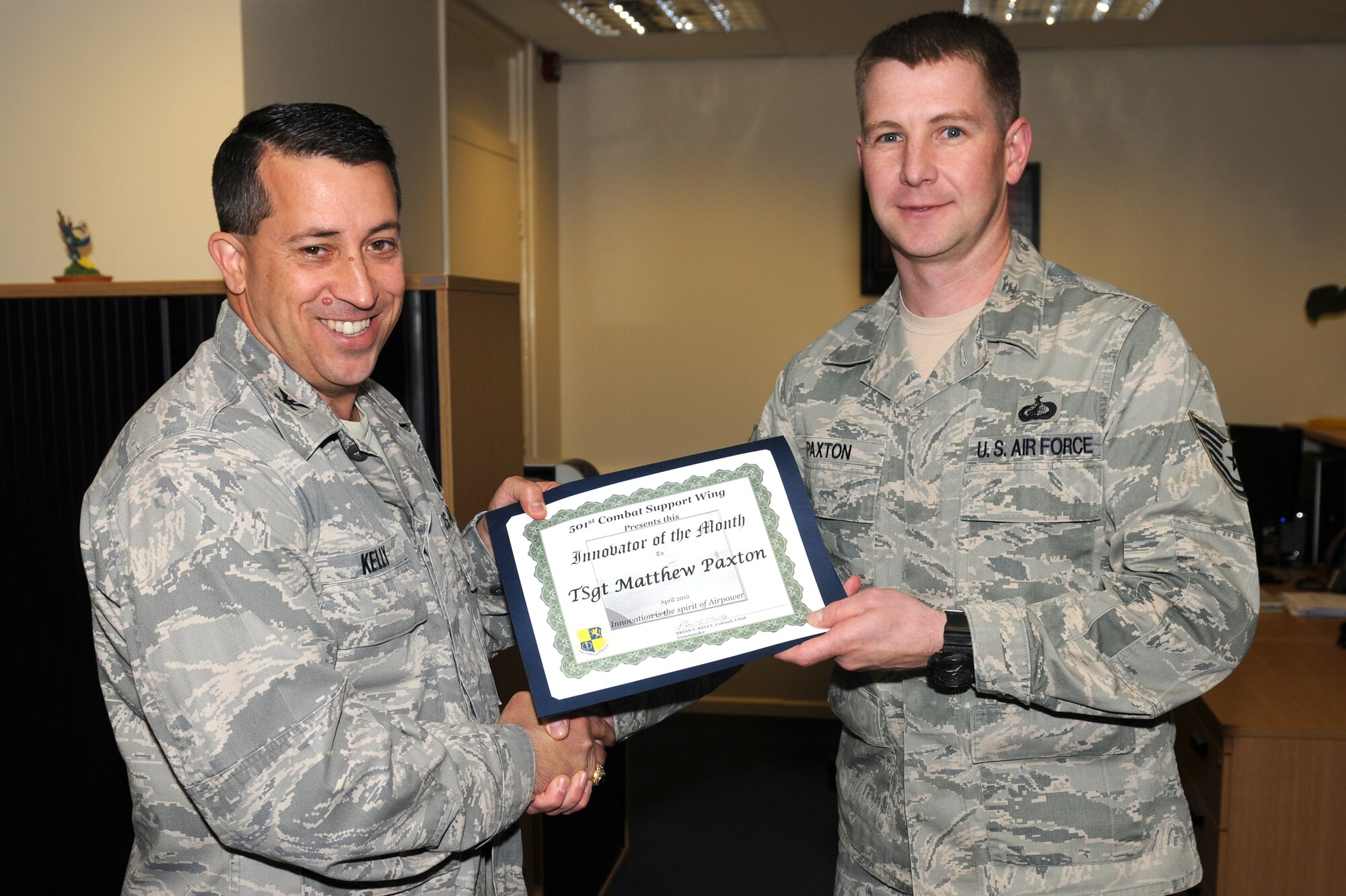 RAF ALCONBURY, United Kingdom - Col. Brian Kelly, 501st Combat Support Wing commander, presents the Innovator of the Month Award to Tech. Sgt. Matthew Paxton, 501st CSW Staff. Paxton created a tracking worksheet for all services contracts. This initiative helps save man hours and effort for pre-award actions as well as post-award administration man hours. (U.S. Air Force photo by Senior Airman Joel Mease) 
