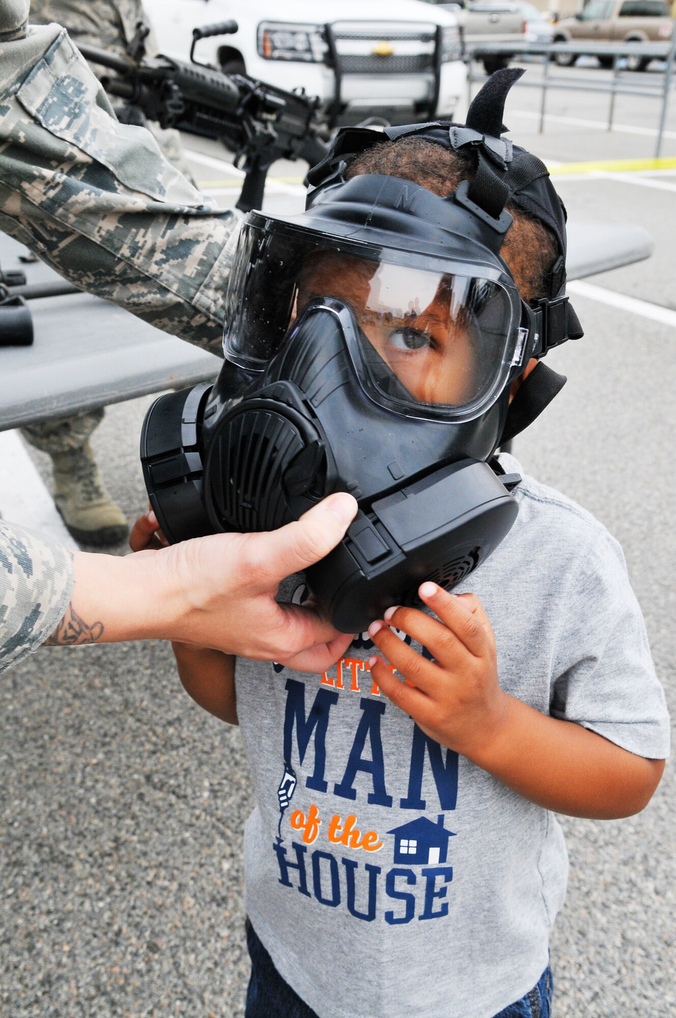 Jhordin Luzik, 3, tries on a gas mask at the 78th Security Forces Squadron display Saturday at Home Depot for National Police Week.(U. S. Air Force photo by Sue Sapp)