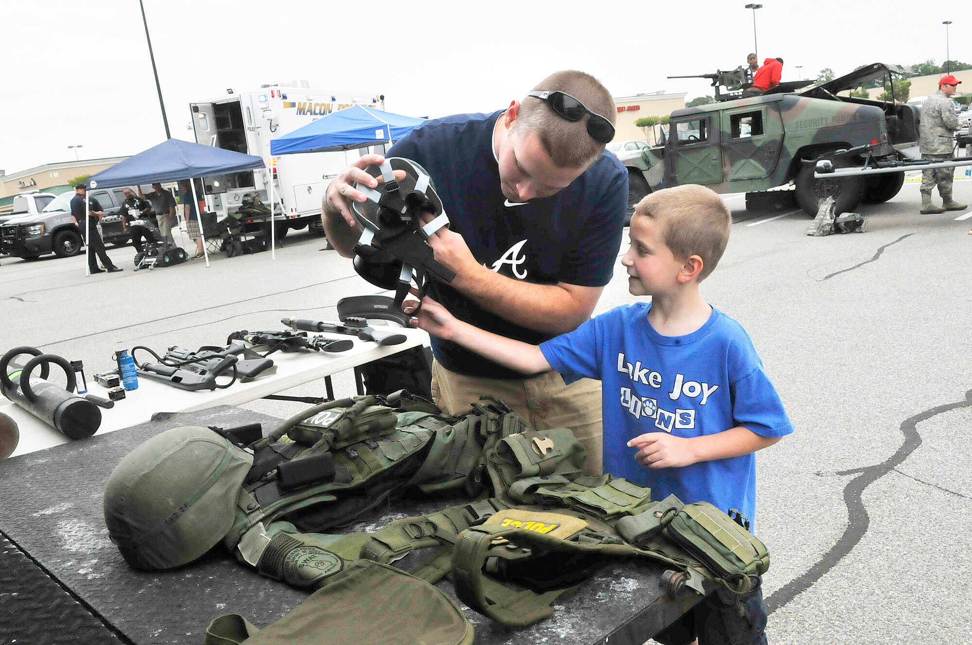 Rob Belknap and his son Braden, 7, look at some of the equipment used by WRPD SWAT team. Police Departments from Macon, Warner Robins, Centerville, Byron and Robins Air Force Base were represented at a display Saturday at Home Depot for National Police Week. (U. S. Air Force photo by Sue Sapp)