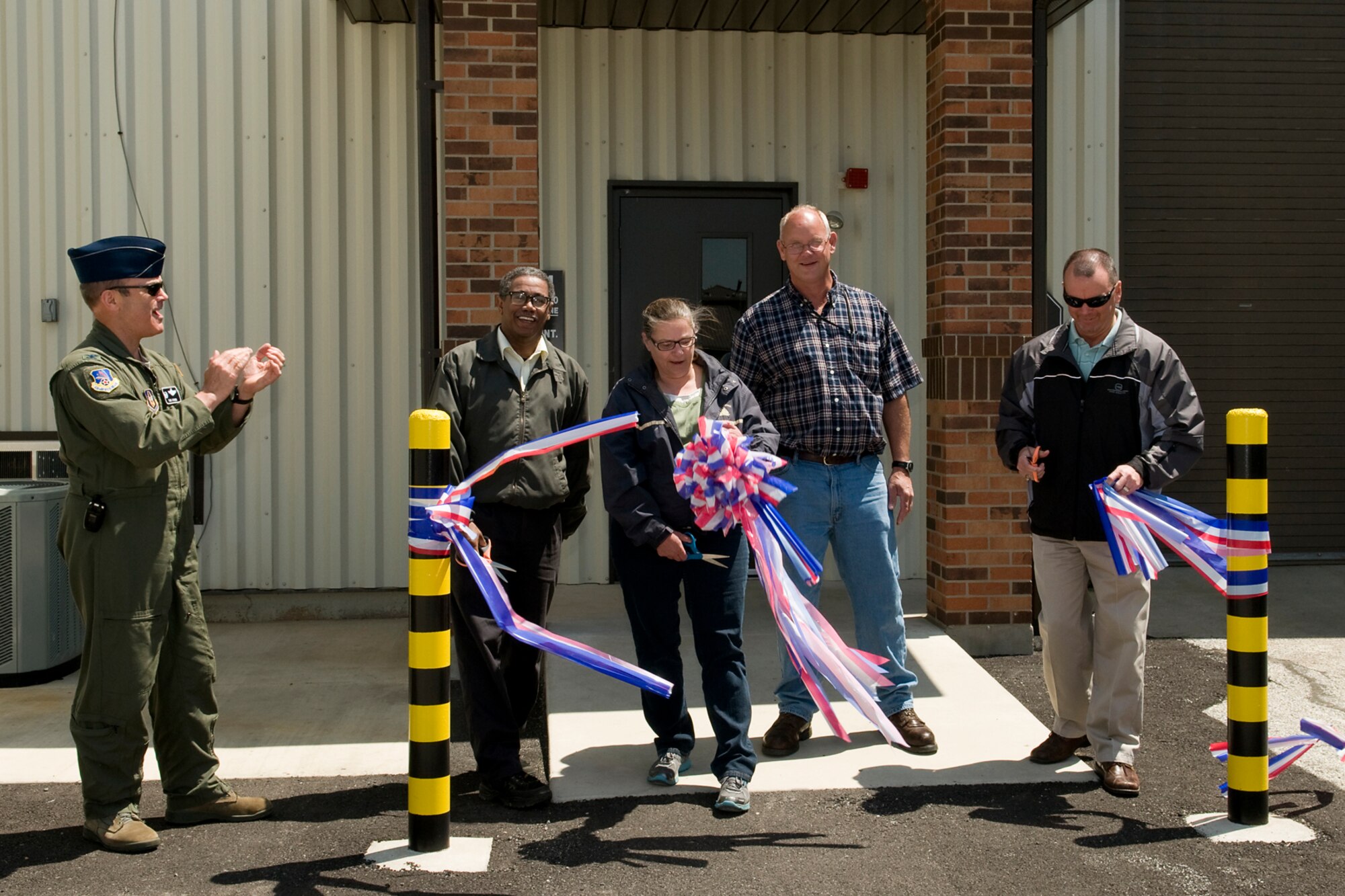GRISSOM AIR RESERVE BASE, Ind. -- Col. William T. "Tim" Cahoon applauds as Wayne Raby, Susan McConnaghy, Jeffrey Snider and Neil Smith cut a ribbon and officially open Grissom's newly renovated vehicle maintenance facility May 10. Cahoon is the 434th Air Refueling Wing commander, Raby is a base architect, McConnaghy is a vehicle accountability officer, Snider is a construction inspector and Smith is a project manager with a base contractor. (U.S. Air Force photo/Tech. Sgt. Mark R. W. Orders-Woempner)
