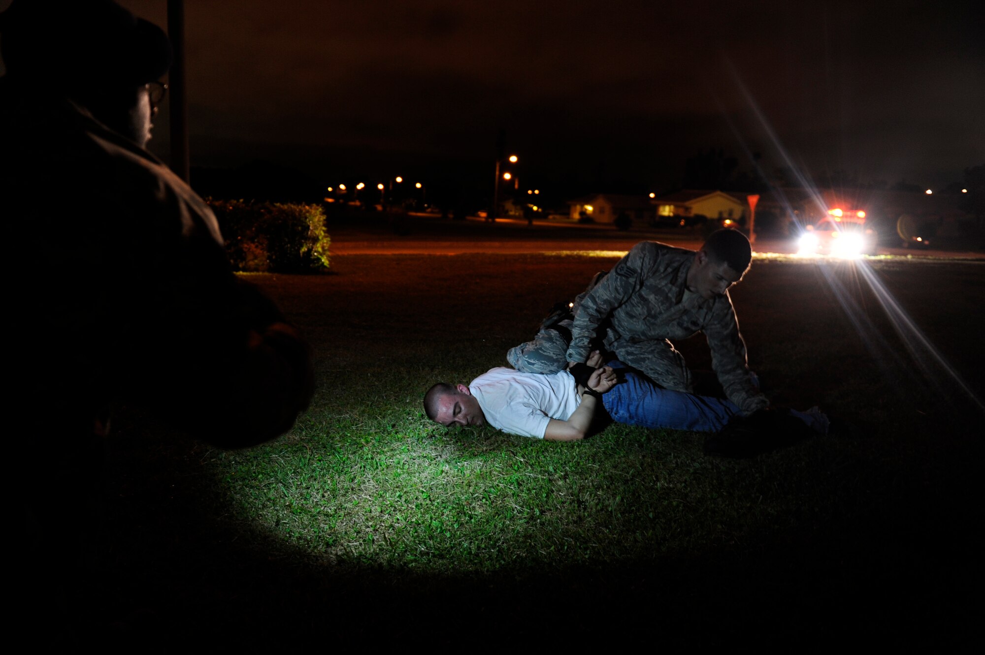 An 18th Security Forces Squadron response force member shines his flashlight on a simulated suspect, U.S. Air Force Airman 1st Class Andrew Chilcoat, 733rd Air Mobility Squadron air freight specialist, as U.S. Air Force Staff Sgt. Robert West, 18th Security Forces response force leader, searches the simulated robber for contraband during Beverly High 12-4, a local operational readiness exercise on Kadena Air Base, Japan, May 14, 2012. Kadena uses LOREs to hone Airmen's skills in order to improve security for its host nation and allies in the Asia-Pacific region. (U.S. Air Force photo/Airman 1st Class Maeson L. Elleman)