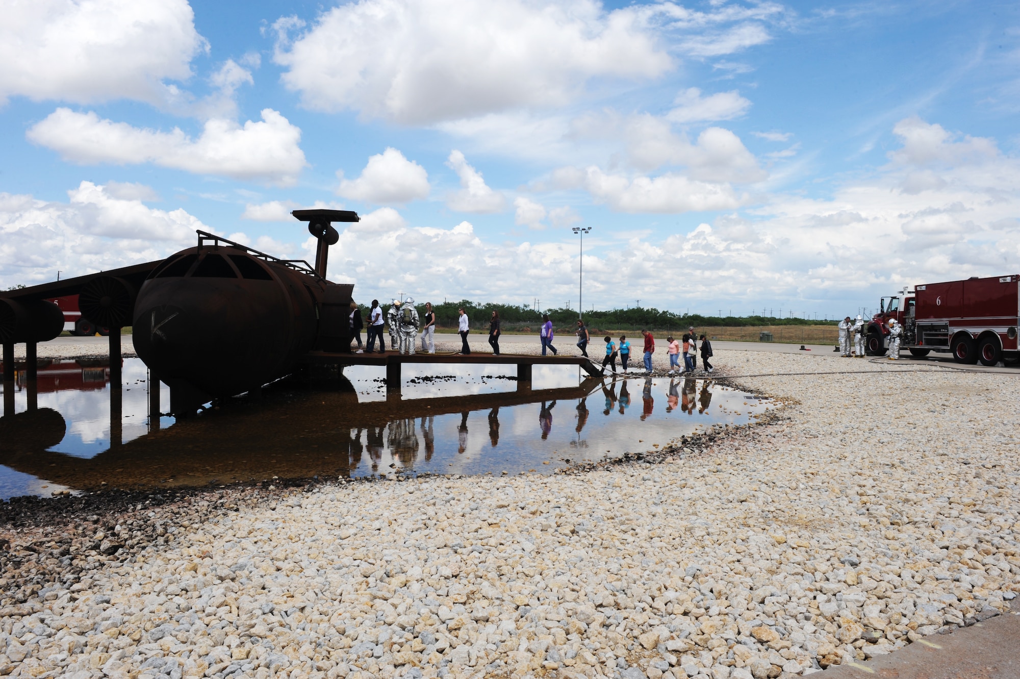 A group of spouses tour the fire fighting training complex, during the 2012 Team Dyess Military Spouse Appreciation Day May 11, 2012, at Dyess Air Force Base, Texas. The event included security forces K-9, firefighting and EOD demonstrations, as well as a tour of a B-1 simulator and weapons load crew training facility. (U.S. Air Force photo by Staff Sgt. Richard P. Ebensberger/ Released)