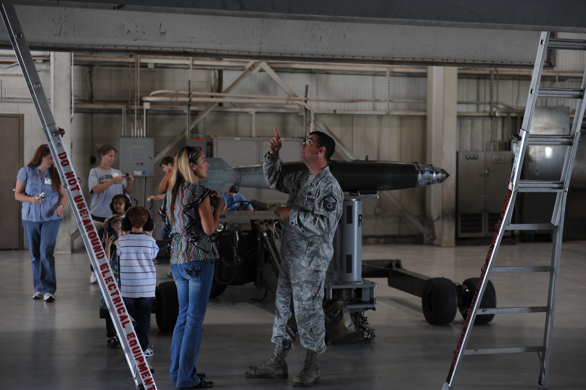 U.S. Air Force Master Sgt. Troy Drasher, 7th Munitions Squadron weapons standardization crew member, explains how to load weapons on a B-1 during the 2012 Team Dyess Military Spouse Appreciation Day May 11, 2012, at Dyess Air Force Base, Texas The event included security forces K-9, firefighting and EOD demonstrations, as well as a tour of a B-1 simulator and weapons load crew training facility. (U.S. Air Force photo by Staff Sgt. Richard P. Ebensberger/ Released)
