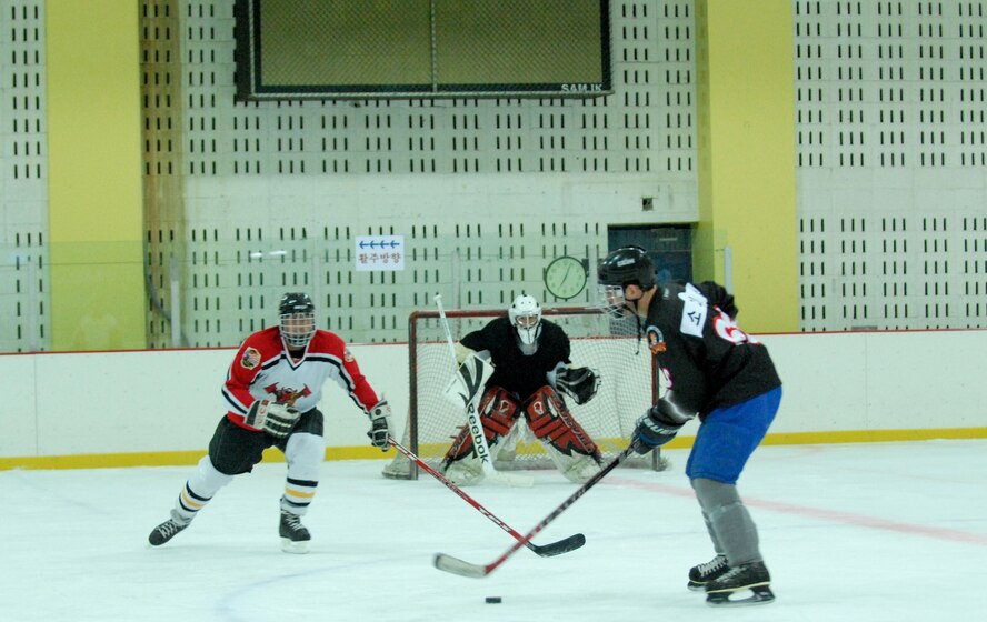Staff Sgt. Gianpierre Salazar, 8th Civil Engineer Squadron firefighter, works to block a shot from a South Korean opponent during a practice session May 13, 2012, in Jeonju, South Korea. Airmen from Kunsan Air Base travel about 45 minutes each weekend to play against South Koreans and Canadians, and keep their hockey skills up to par. (U.S. Air Force photo/Senior Airman Brigitte N. Brantley) 
