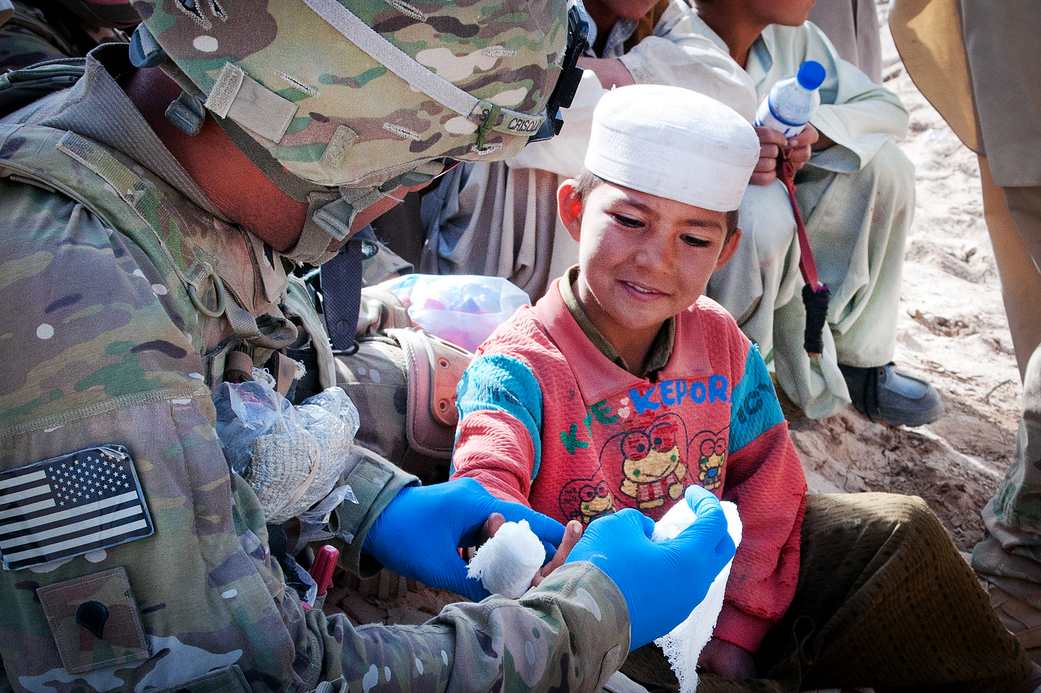 U.s. Army Spc. Arnie Crisolo Bandages Burns On An Afghan Child's Hand In A  Village In