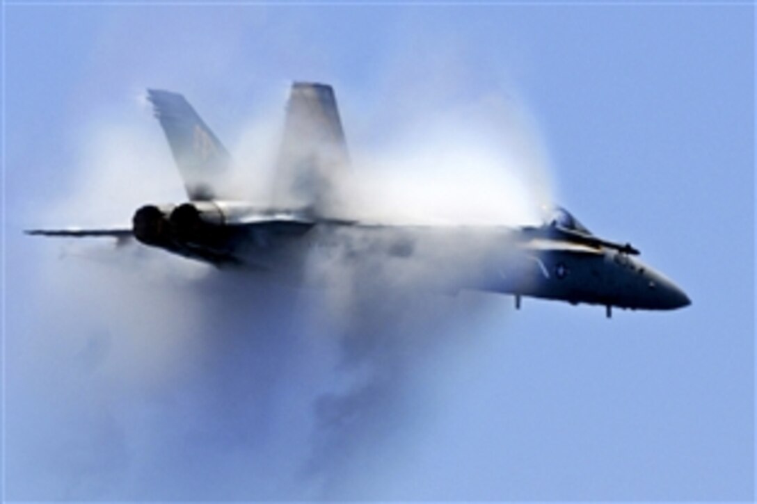 An FA-18C Hornet flies supersonic over the aircraft carrier USS Carl Vinson during an air power demonstration in the Pacific Ocean, May 14, 2012. The Carl Vinson and Carrier Air Wing 17 are deployed to the U.S. 3rd Fleet area of operations. The Hornet is assigned to Strike Fighter Squadron 2.