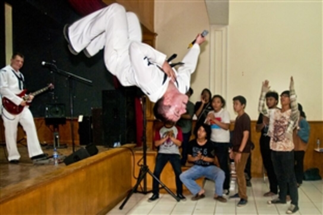 U.S. Navy Petty Officer 3rd Class Gabriel Brown performs a back flip off the stage during a performance for Indonesians at the University of Indonesia in Jakarta, May 13, 2012. Brown is a musician with the U.S. 7th Fleet Band, Orient Express, which is in Jakarta with the U.S. 7th Fleet flagship USS Blue Ridge for a port visit. 