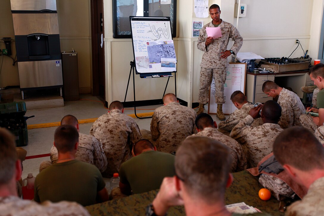 Second Lt. Mitchell X. Rhyner, platoon commander, Security Element, Maritime Raid Force, 15th Marine Expeditionary Unit, briefs his Marines at Naval Air Facility El Centro, Calif., on their upcoming raid taking place in the Chocolate Mountains, Calif., May 15. The mission was to capture a high-value individual who was reported to be a key leader of a local terrorist organization during the ground portion of Realistic Urban Training. Rhyner, 24, is from State College, Pa.