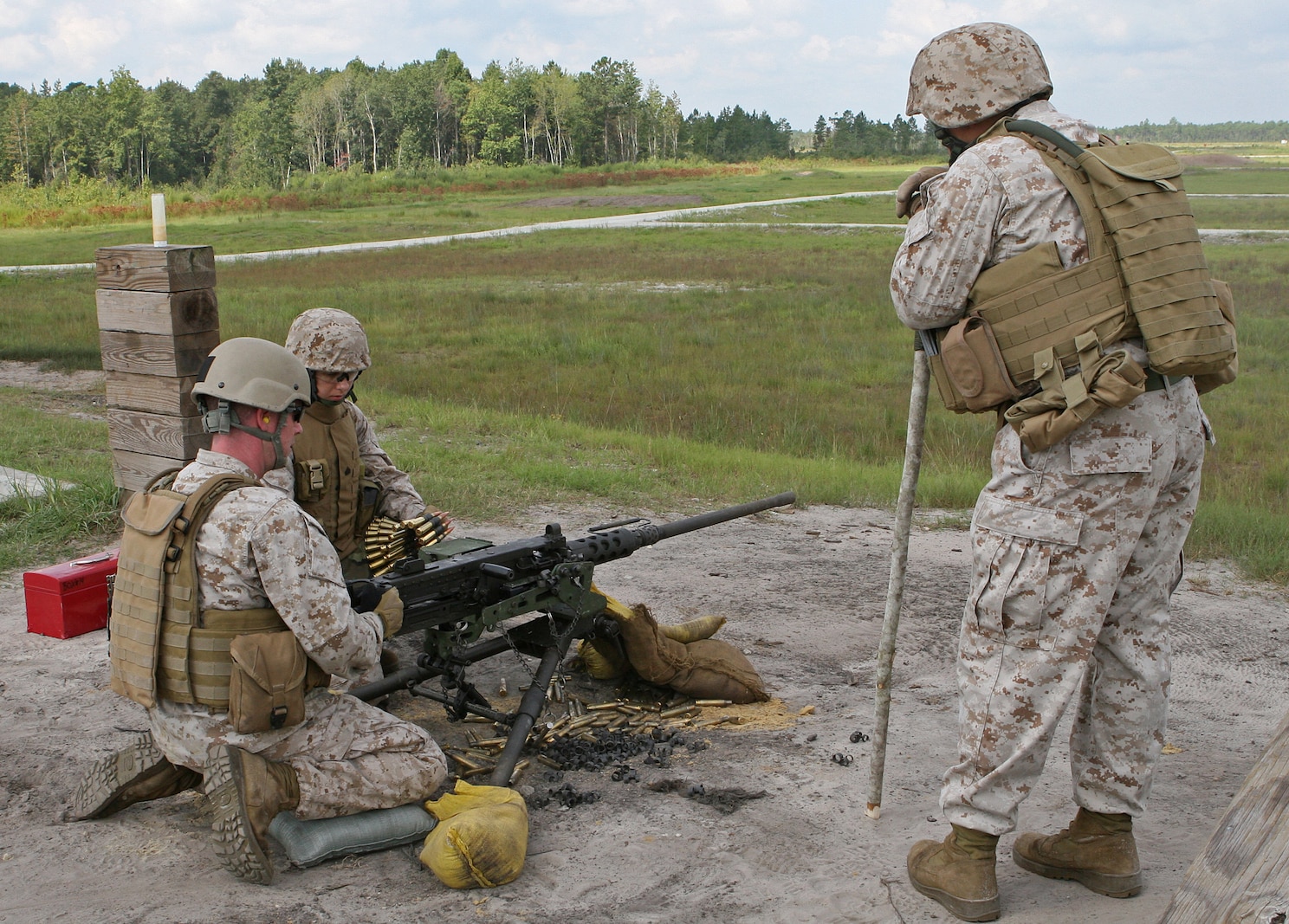 Gunnery Sgt. William Abernathy, the company first sergeant for Military Police Support Comapny, II Marine Expeditionary Force Headquarters Group supervises two Marines in loading and firing a .50 caliber Browning machine gun aboard Marine Corps Base Camp Lejeune, N.C., Aug. 28, 2010. Abernathy uses the stick he is leaning on to get the attention of his Marines when the sounds of the machine guns drown out his voice.