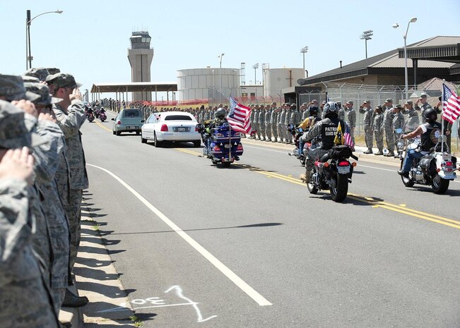 Members of the Patriot Guard Riders follow the motorcade of U.S. Army Spc. Chase Marta as members of Team Beale pay their respects with a salute during a dignified transfer at Beale Air Force Base, Calif., May 16, 2012. Marta, a Yuba City native, was killed in combat May 7 by an IED while serving in Afghanistan. More than 1,000 Airmen lined the motorcade route to pay their respects with a salute as the procession exited the base. (U.S. Air Force photo by John Schwab/Released)