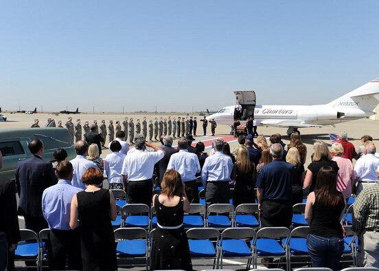 Family and friends of U.S. Army Spc. Chase Marta and members of Team Beale pay their respects during a dignified transfer at Beale Air Force Base, Calif., May 16, 2012. Marta, a Yuba City native, was killed in combat May 7 by an IED while serving in Afghanistan. More than 1,000 Airmen lined the motorcade route to pay their respects with a salute as the procession exited the base. (U.S. Air Force photo by John Schwab/Released)