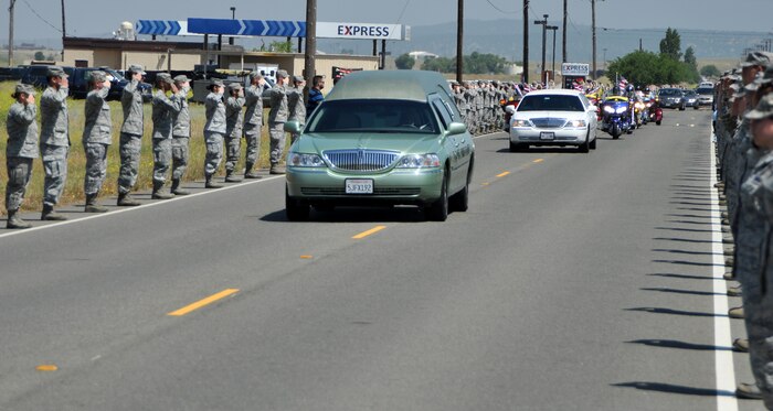 Beale Airmen salute the motorcade of U.S. Army Spc. Chase Marta during a dignified transfer at Beale Air Force Base, Calif., May 16, 2012. Marta, a Yuba City native, was killed in combat May 7 by an IED while serving in Afghanistan. More than 1,000 Airmen lined the motorcade route to pay their respects with a salute as the procession exited the base. (U.S. Air Force photo by Robert Scott/Released)