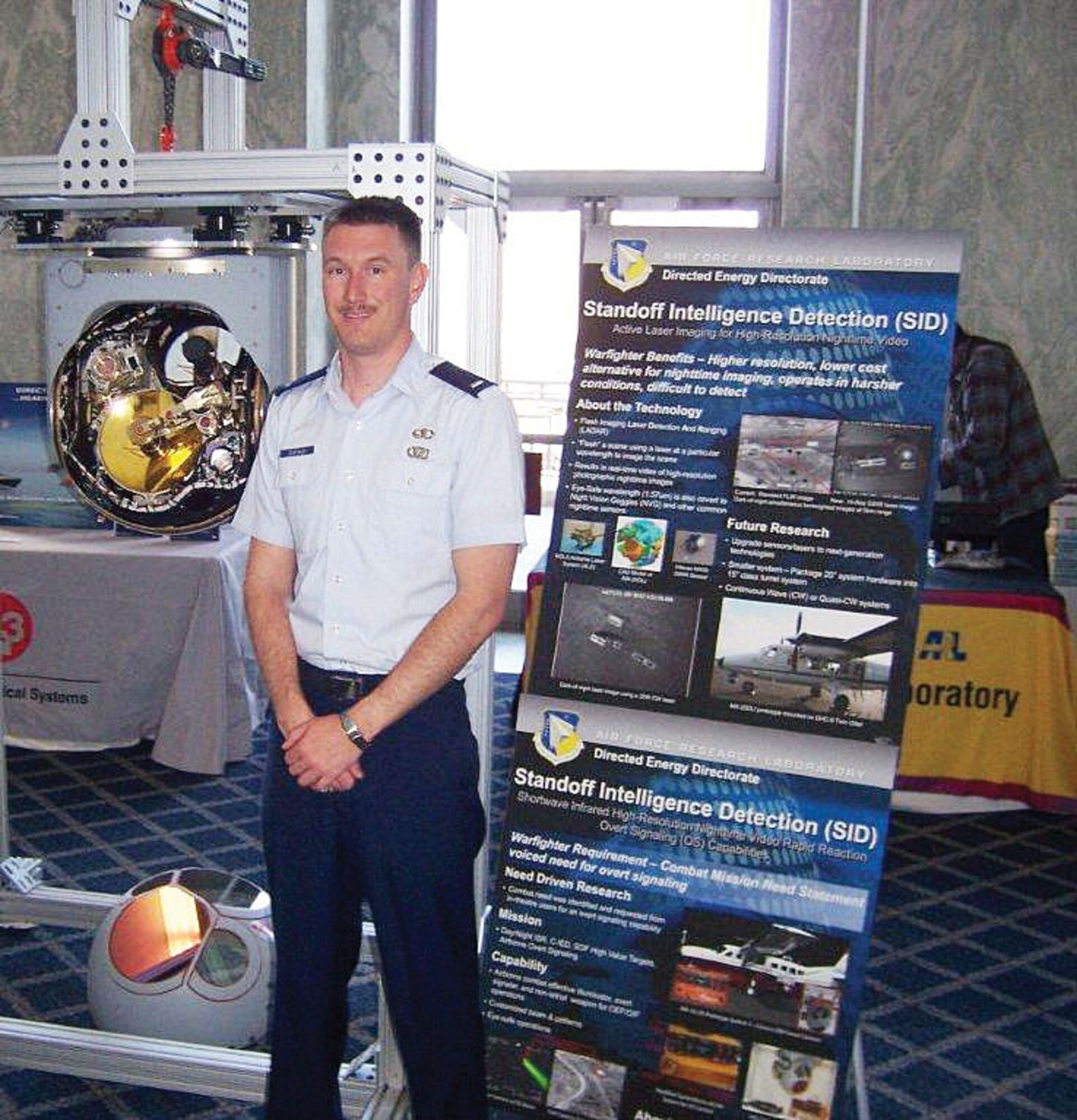 KIRTLAND AFB, N.M. -- 1st Lt. Kyle DuFaud, Air Force Research Laboratory Directed Energy Directorate, displays the Standoff Intelligence Detection System at the Rayburn House Office Building in Washington, D.C. The system provides warfighters high-resolution nighttime imaging. (Courtesy photo)