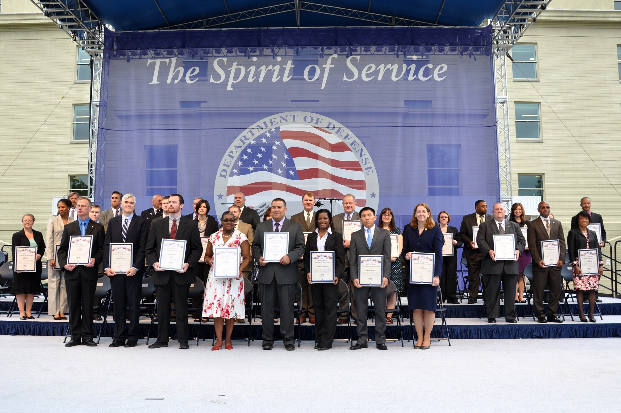 Air Force District of Washington’s Judy Gibson (fourth from the left), plans and requirements, and Brian K. Halston (fourth from the right), contracting, stand among the 34 public servants from across DOD who received the Department of Defense Spirit of Service Recognition Award at the Pentagon, May 9.  The award honors DOD civilian employees from the National Capital Region who display core qualities of Honor, Integrity and Excellence in their everyday support to the Department. (Courtesy Photo)