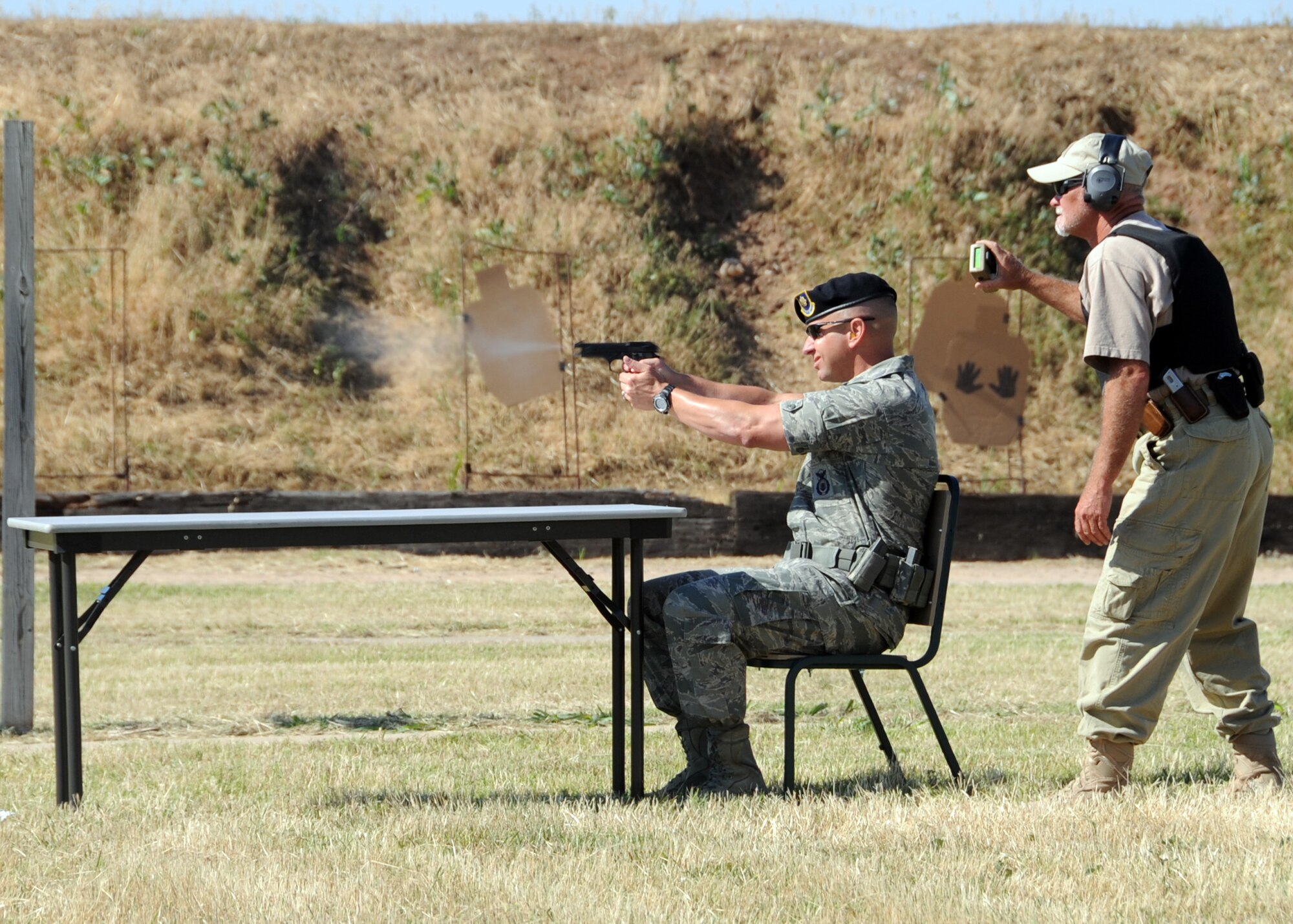 ALTUS, Okla. – Maj. Micheal J. Jewell, 97th Security Forces Squadron commander, fires an M-9 berretta while Phillip Beauchamp, Jackson County Sheriff’s office deputy, times his trial at the Altus Police Department shooting range, May 16, 2012. The pistol competition is an annual event between Altus PD, 97th SFS, and local surrounding law enforcement departments held each year during Police Week. (U.S. Air Force photo by Airman 1st Class Franklin R. Ramos / 97th Air Mobility Wing / Released)