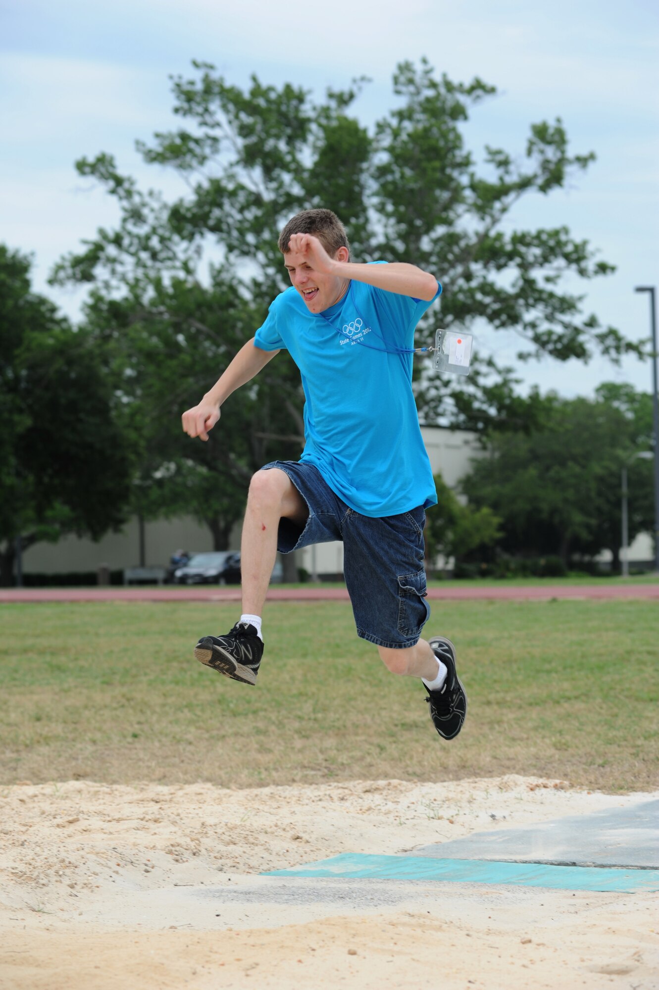 Collin Sartin, athlete, leaps into the air during his turn in the running long jump competition during the Special Olympics Mississippi Summer Games, May 12, 2012, at Keesler Air Force Base, Miss. It’s the 26th year that Keesler has hosted the statewide event. Opening ceremonies took place May 11. Athletic competitions took place throughout the day and were followed by a victory dance May 12. More than 1,200 athletes and coaches and 3,000 volunteers joined forces to make the event a success.  (U.S. Air Force photo by Kemberly Groue)