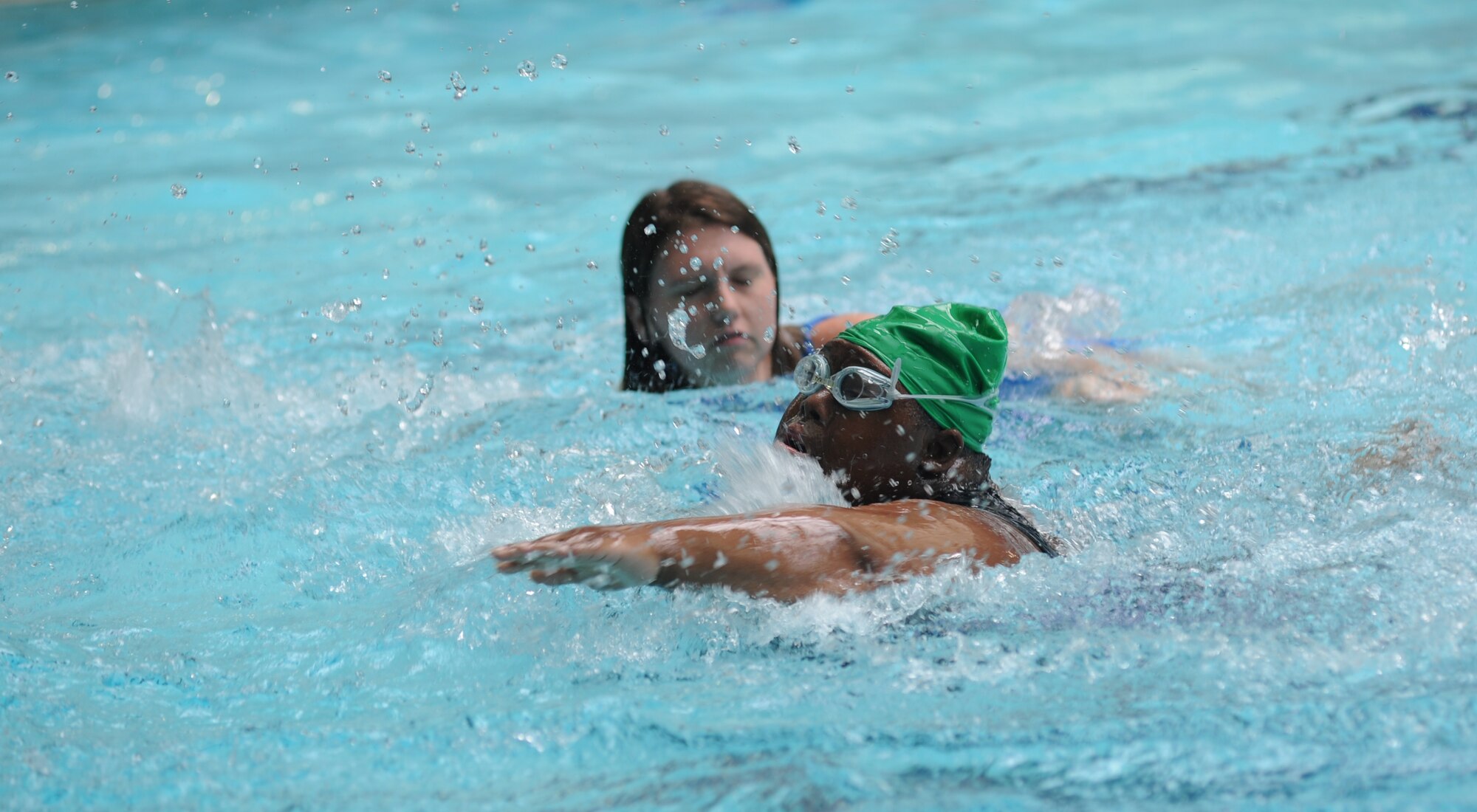 Olivia Jones, athlete, trails behind athlete Rosekita Johnson in the 15-meter unassisted swim competition at the Biloxi Natatorium, Biloxi, Miss., during the Special Olympics Mississippi Summer Games, May 12, 2012.  It’s the 26th year that Keesler Air Force Base, Miss., has hosted the statewide event. Opening ceremonies took place May 11. Athletic competitions took place throughout the day and were followed by a victory dance May 12. More than 1,200 athletes and coaches and 3,000 volunteers joined forces to make the event a success.  (U.S. Air Force photo by Kemberly Groue)
