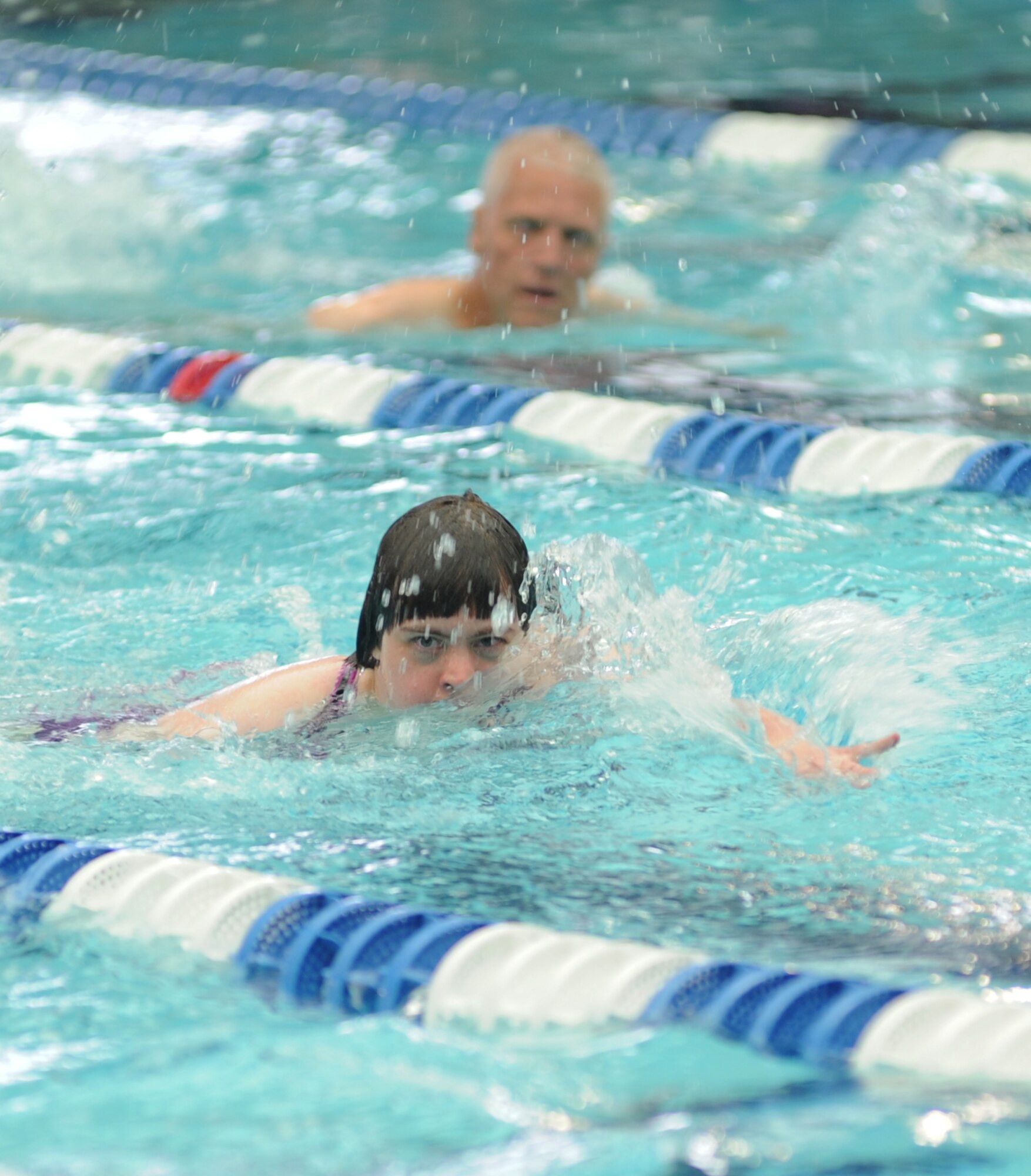 David Robertson, athlete, trails behind athlete Beth Ann Sullender in the 100-meter freestyle swim competition at the Biloxi Natatorium, Biloxi, Miss., during the Special Olympics Mississippi Summer Games, May 12, 2012. It’s the 26th year that Keesler Air Force Base, Miss., has hosted the statewide event. Opening ceremonies took place May 11. Athletic competitions took place throughout the day and were followed by a victory dance May 12. More than 1,200 athletes and coaches and 3,000 volunteers joined forces to make the event a success.  (U.S. Air Force photo by Kemberly Groue)