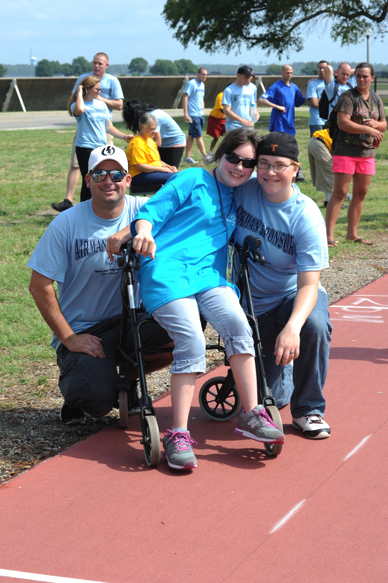 Airmen 1st Class Brian Bryant and Candace Vessels, 338th Training Squadron, pose for a photo with their sponsored athlete, Shelby Smith, 15, following the completion of the 25-meter assisted walk during the Special Olympics Mississippi Summer Games, May 12, 2012, at Keesler Air Force Base, Miss. It’s the 26th year that Keesler has hosted the statewide event. Opening ceremonies took place May 11. Athletic competitions took place throughout the day and were followed by a victory dance May 12. More than 1,200 athletes and coaches and 3,000 volunteers joined forces to make the event a success.  (U.S. Air Force photo by Kemberly Groue)