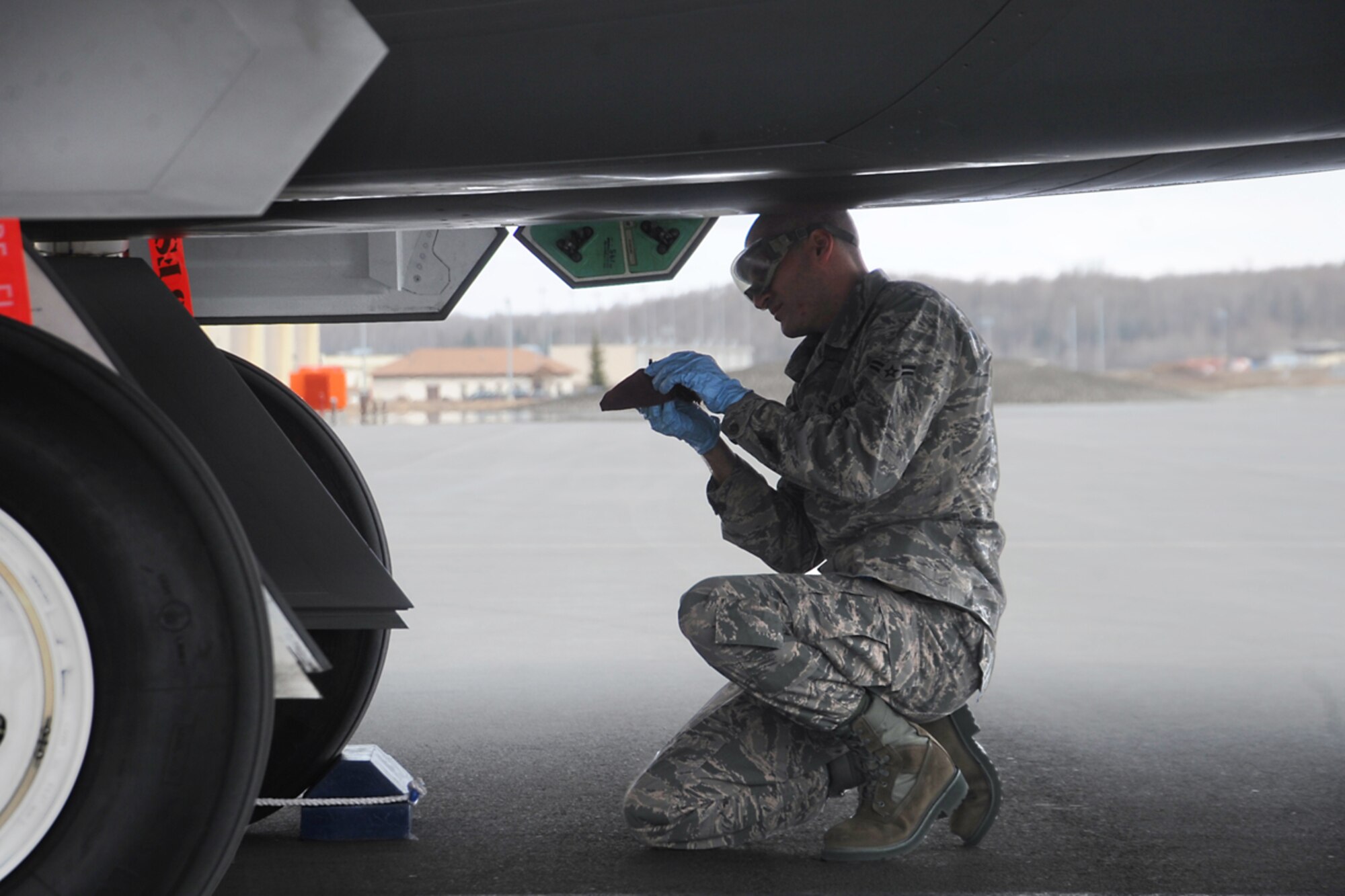 Airman 1st Class Jeffery Brown performs post flight checks after an F-22 Raptor fighter landed on the flightline May 5. The 525th Fighter Squadron, Joint Base Elmendorf-Richardson, received the last F-22 Raptor being made from Lockheed Martin and has named it its squadron's flagship. Brown is the jet's assistant dedicated crew chief with the 525th Aircraft Maintenance Unit from Booneville, Miss. (U.S. Air Force photo/Staff Sgt. Cynthia Spalding)
