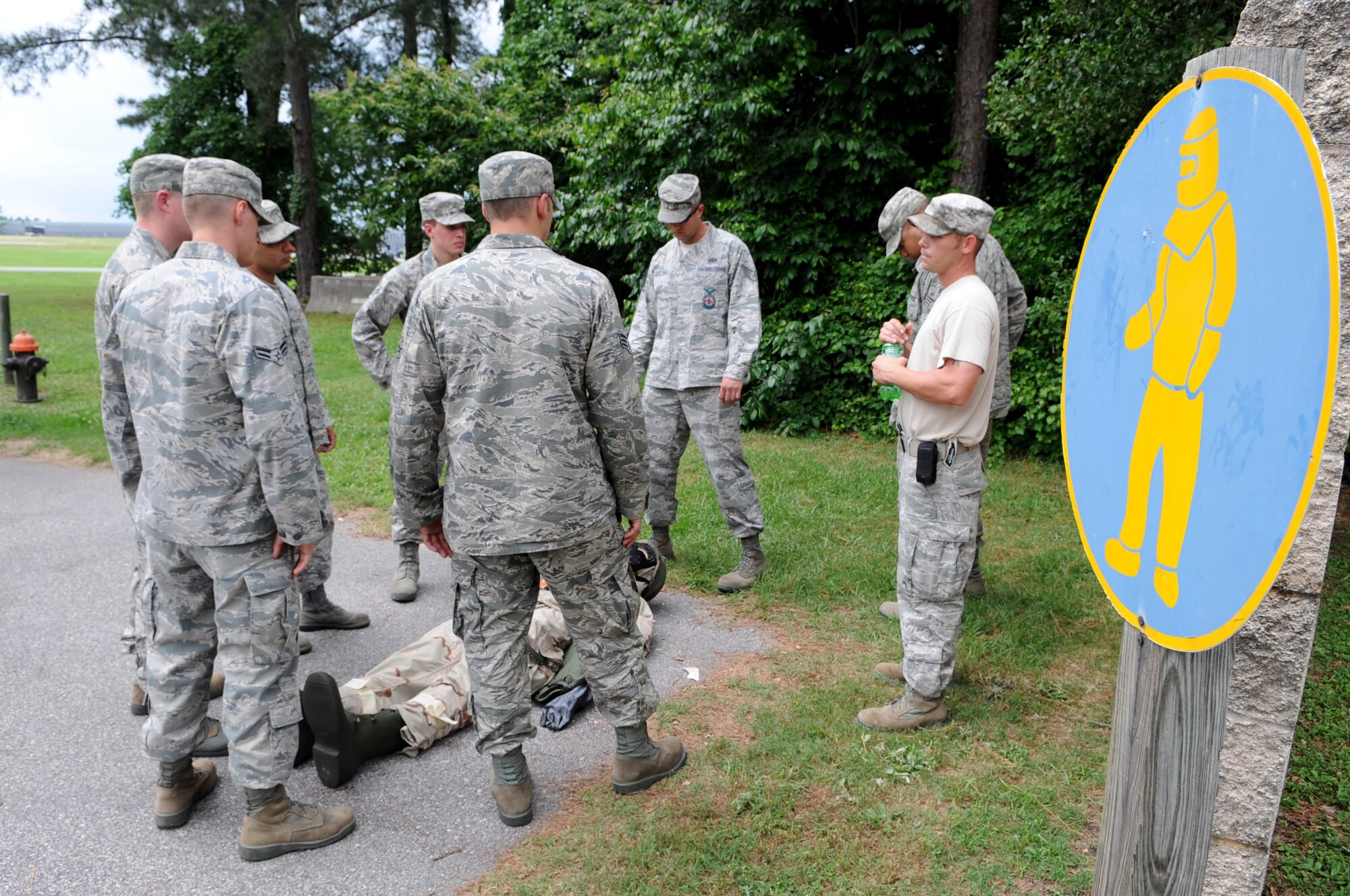 U.S. Air Force Airmen assigned to the 4th Civil Engineer Squadron surround a dummy while awaiting further instruction during ability to survive and operate training in a chemical, biological, radiological and nuclear environment on Seymour Johnson Air Force Base, N.C., May 15, 2012. Airmen often use a dummy to practice buddy care techniques during simulated CBRN attacks. (U.S. Air Force photo/Airman 1st Class Aubrey Robinson/Released)