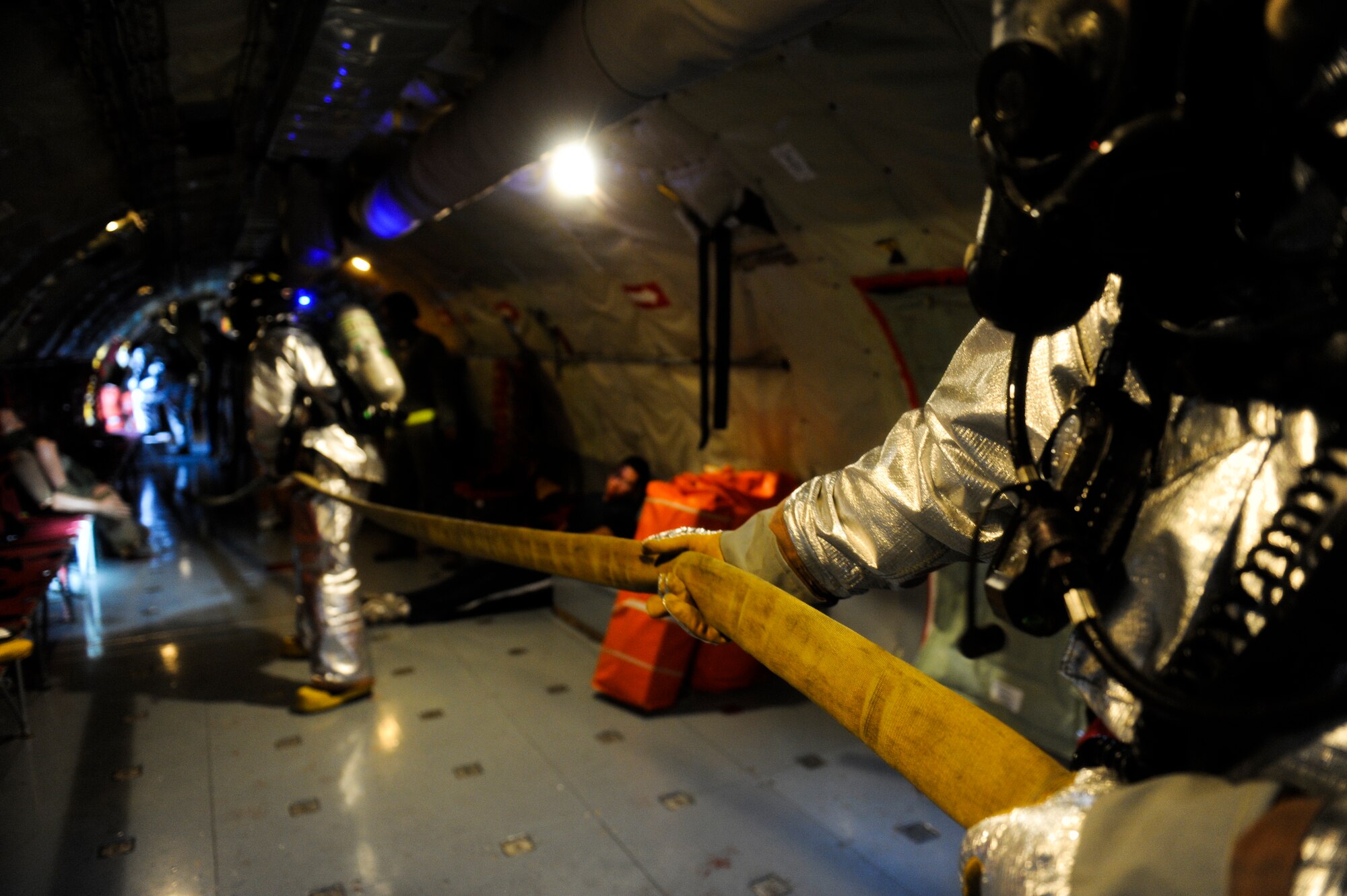 Kadena firefighters drag a fire hose through a KC-135 Stratotanker aerial refueling aircraft during a simulated aircraft fire as part of Beverly High 12-4, a local operational readiness exercise on Kadena Air Base, Japan, May 16, 2012. Kadena's Airmen use LOREs to test themselves in the ability to survive and operate (ATSO) under various conditions in order to prepare them for future contingencies. (U.S. Air Force photo/Airman 1st Class Maeson L. Elleman)