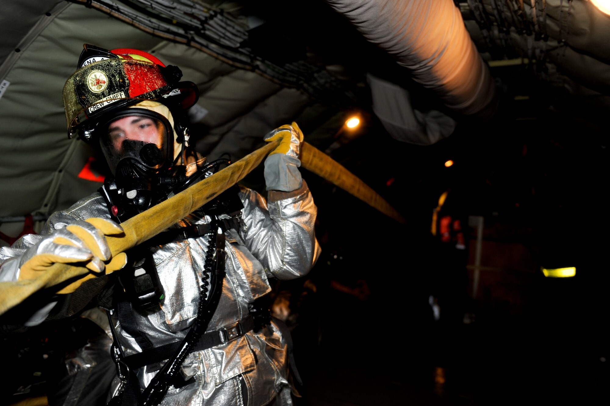 A U.S. Air Force firefighter from the 18th Wing drags a fire hose through a KC-135 Stratotanker aerial refueling aircraft during a simulated aircraft fire as part of Beverly High 12-4, a local operational readiness exercise on Kadena Air Base, Japan, May 16, 2012. Kadena Airmen participate in LOREs to improve life-saving skills and prepare them for future real-world contingencies. (U.S. Air Force photo/Airman 1st Class Maeson L. Elleman)