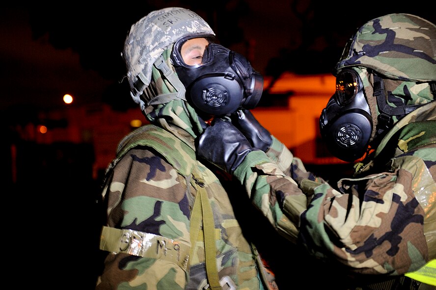 U.S. Air Force Staff Sgt. Mathew Bray, 18th Communication Squadron cyber transport technician, performs a buddy check on U.S. Air Force Senior Airman Simon Tan, 18th Communication Squadron client systems technician, after Tan took off his mask while pretending to be claustrophobic for a training scenario during local operational readiness exercise Beverly High 12-4 on Kadena Air Base, Japan, May 16, 2012. The training scenario tested the Airmen’s ability to keep each other safe from potential contamination during a post-attack reconnaissance sweep. LOREs are conducted on a regular basis to test the base's ability to defend Japan and maintain peace and stability in the Pacific region. (U.S. Air Force photo/Airman 1st Class Brooke P. Beers)
