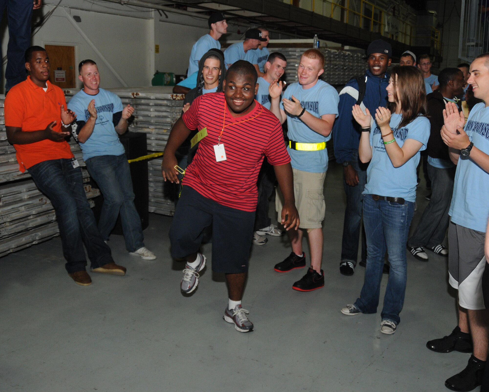 Airmen sponsors cheer on Jay Davis, athlete, as he displays a few moves during the victory dance, inside a Hangar, following closing ceremonies and ending the Special Olympics Mississippi Summer Games, May 12, 2012, at Keesler Air Force Base, Miss. It’s the 26th year that Keesler has hosted the statewide event. Opening ceremonies took place May 11. Athletic competitions took place throughout the day and were followed by a victory dance May 12. More than 1,200 athletes and coaches and 3,000 volunteers joined forces to make the event a success.  (U.S. Air Force photo by Kemberly Groue)