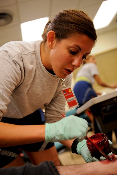 U.S. Air Force Senior Airman Kendra Fonteyne, 18th Aerospace Medicine Squadron aerospace physiology technician, applies fake blood to a wound on a simulated victim’s leg for a training inject during local operational readiness exercise Beverly High 12-4 on Kadena Air Base, Japan, May 16, 2012. Special effects makeup is used to offer a more realistic experience during self-aid and buddy care training scenarios. The LORE is designed to train Kadena’s Airmen to survive and operate under various conditions. (U.S. Air Force photo/ Airman 1st Class Brooke P. Beers)