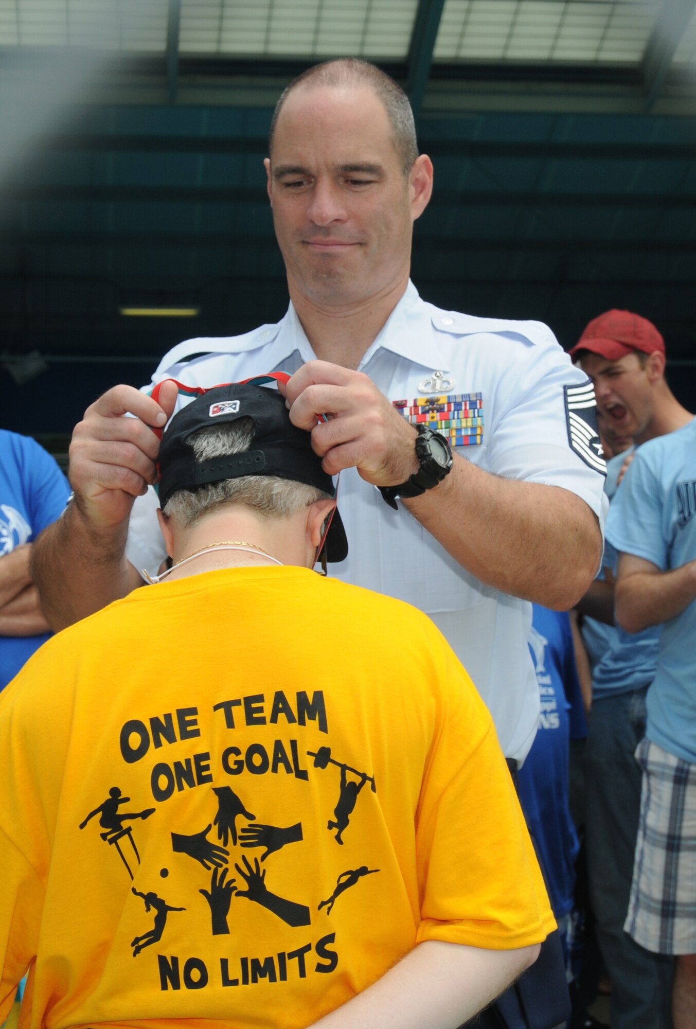 Chief Master Sgt. Richard Boulanger, 334th Training Squadron, places a medal around an athlete’s neck during the aquatics competition at the Special Olympics Mississippi Summer Games at the Biloxi Natatorium May 12, 2012, Biloxi, Miss.  It’s the 26th year that the statewide event has been hosted by Keesler Air Force Base, Miss. Opening ceremonies took place May 11. Athletic competitions took place throughout the day and were followed by a victory dance May 12. More than 1,200 athletes and coaches and 3,000 volunteers joined forces to make the event a success.  (U.S. Air Force photo by Kemberly Groue)