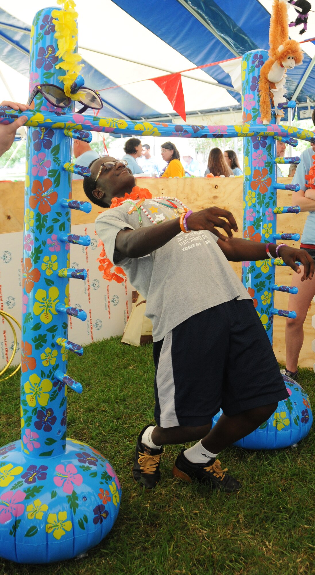 Dana Walton, athlete, participates in the limbo in Olympic Village during the Mississippi Special Olympics Summer Games, May 12, 2012, at Keesler Air Force Base, Miss. It’s the 26th year that Keesler has hosted the statewide event. Opening ceremonies took place May 11. Athletic competitions took place throughout the day and were followed by a victory dance May 12. More than 1,200 athletes and coaches and 3,000 volunteers joined forces to make the event a success.  Olympic Village is an area set up on the parade field with vendors, arts and crafts, games and karaoke for entertaining the athletes while not competing.  (U.S. Air Force photo by Kemberly Groue)