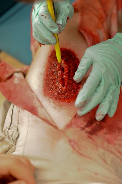 U.S. Air Force Senior Airman Kendra Fonteyne, 18th Aerospace Medicine Squadron aerospace physiology technician, creates a flesh wound on a simulated victim’s leg for a training inject during local operational readiness exercise Beverly High 12-4 on Kadena Air Base, Japan, May 16, 2012. The moulage makeup adds realism and urgency to self-aid and buddy care scenarios. LOREs give Airmen the opportunity to practice readiness skills and prepare for real world contingencies. (U.S. Air Force photo/ Airman 1st Class Brooke P. Beers)
