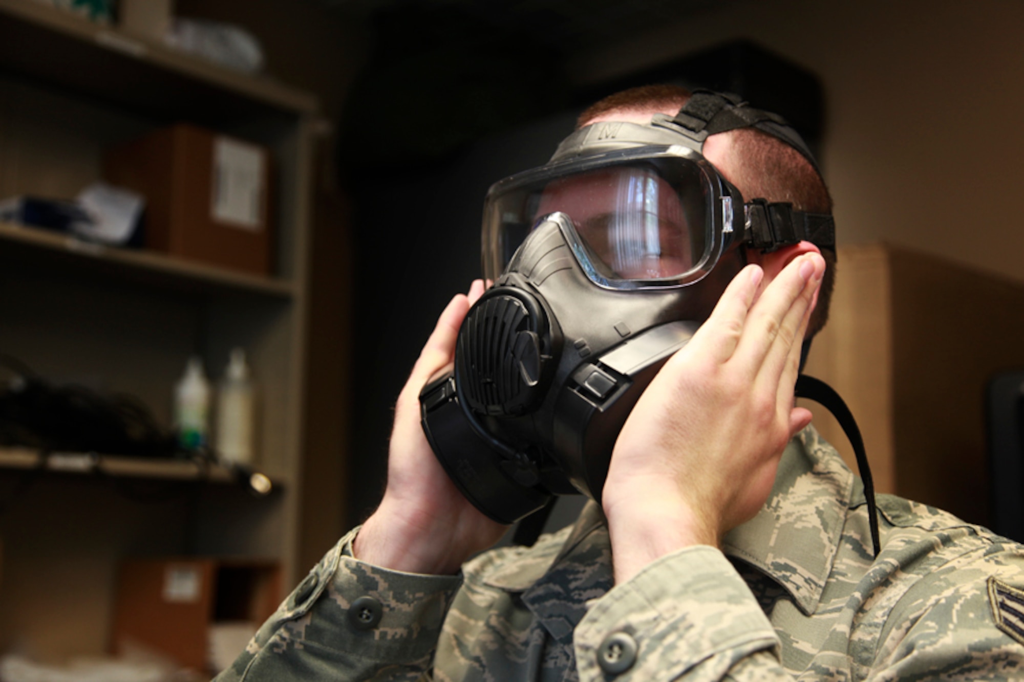 Senior Airman Jonathan Hehnly, a 911th Airlift Wing Public Affairs specialist, checks the vacuum seal of his newly assigned M50 protective mask for air leakage before he proceeds to the next step of the fitting test procedure at building 218, May 11, 2012. Hehnly replaced his old MCU-2/P mask with the new M50 Joint Service General Purpose Mask which is part of the mandatory United States armed forces gas mask exchange that started in 2009. All 911th Reservists are required to make this exchange and receive additional Chemical, Biological, Radiological, Nuclear and Explosives training 90 days before any deployment. (U.S. Air Force photo by Tech. Sgt. Ralph Van Houtem/Released)