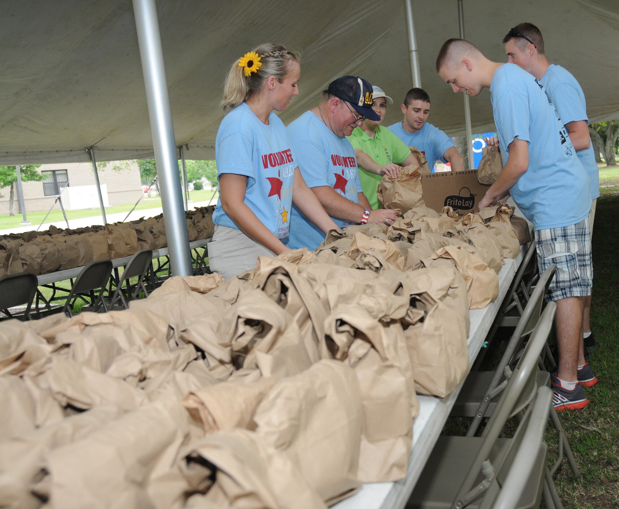 Airman 1st Class Kristen Berckefeldt, 81st Surgical Operations Squadron; Johnny Craig Foshee of Pedal, Miss.; Tech. Sgt. Allison Edwards, Senior Airman Christopher Boyd, and Airman 1st Class Isaiah Owens, 81st Diagnostic and Therapeutics Squadron; and Airman 1st Class Jason Parker, 81st Aerospace Medicine Squadron, volunteer their services by preparing sack lunches for the athletes and volunteers during the Special Olympics Mississippi Summer Games, May 12, 2012, at Keesler Air Force Base, Miss. It’s the 26th year that Keesler has hosted the statewide event. Opening ceremonies took place May 11. Athletic competitions took place throughout the day and were followed by a victory dance May 12. More than 1,200 athletes and coaches and 3,000 volunteers joined forces to make the event a success.  (U.S. Air Force photo by Kemberly Groue)