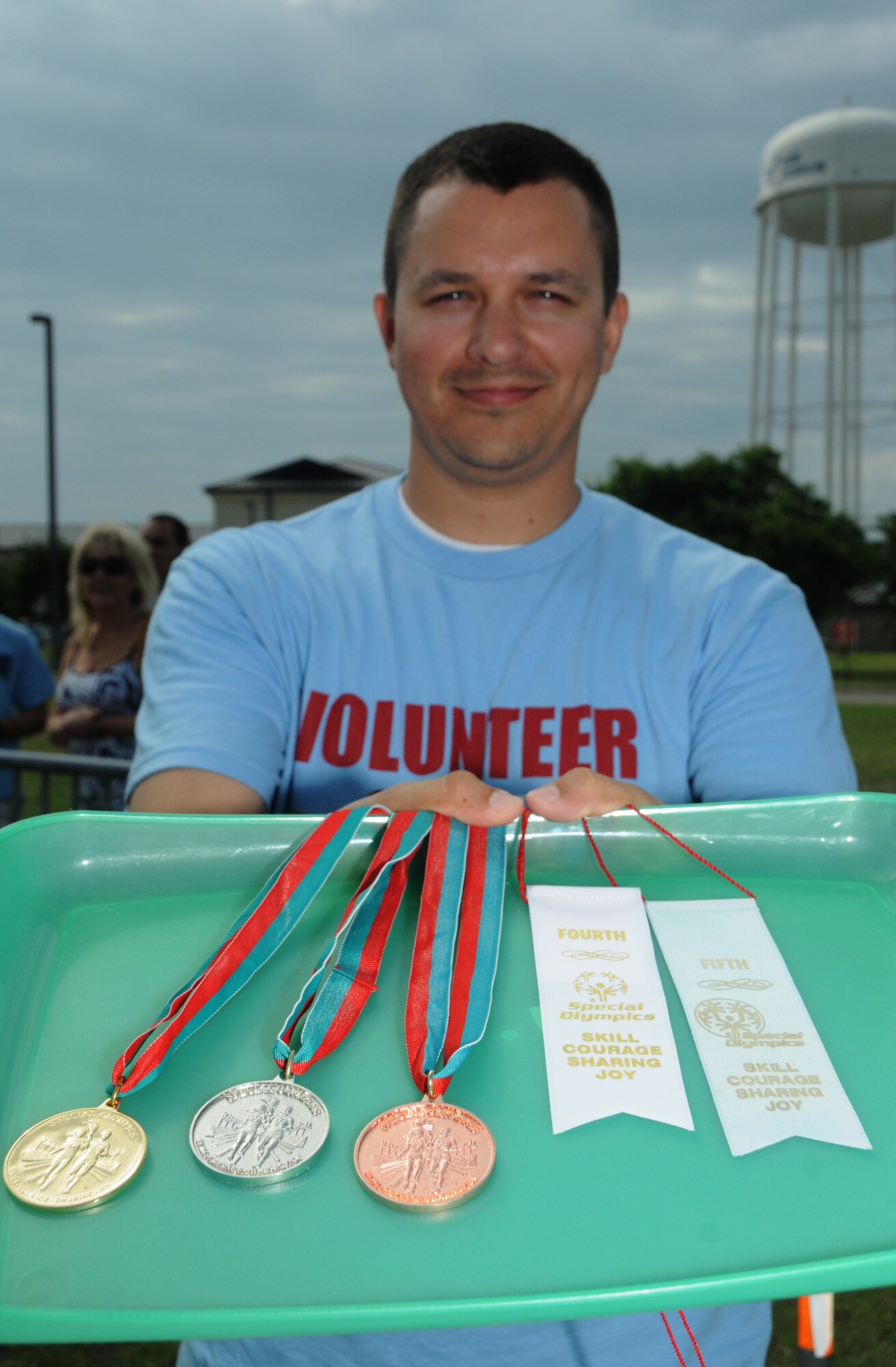 Tech. Sgt. Alex Jordan, Mathies NCO Academy, volunteers his services by presenting medals during the Special Olympics Mississippi Summer Games, May 12, 2012, at Keesler Air Force Base, Miss. It’s the 26th year that Keesler has hosted the statewide event. Opening ceremonies took place May 11. Athletic competitions took place throughout the day and were followed by a victory dance May 12. More than 1,200 athletes and coaches and 3,000 volunteers joined forces to make the event a success.  (U.S. Air Force photo by Kemberly Groue)
