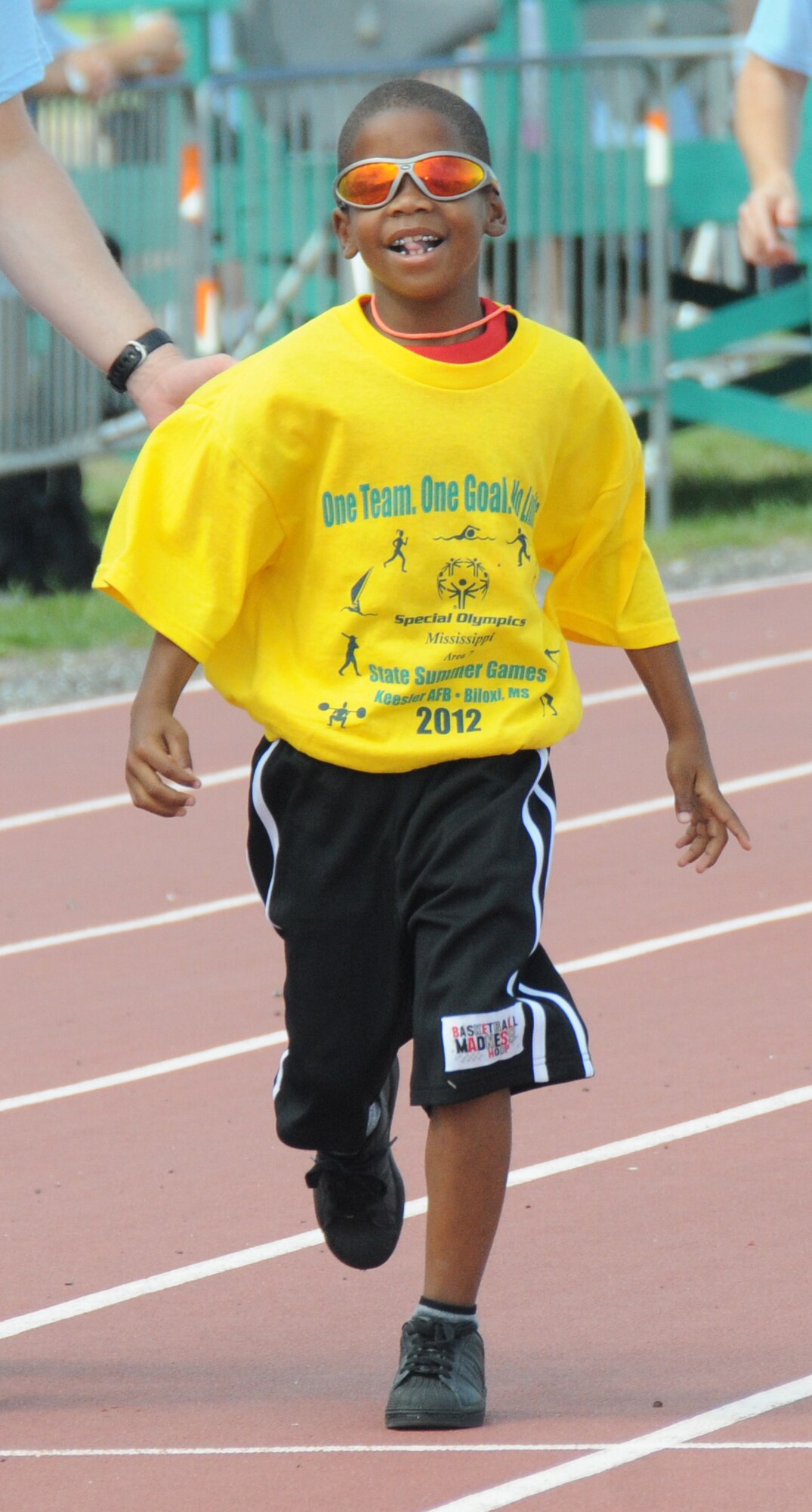 Seven-year-old Jemarea Hill, athlete, participates in the 50-meter assisted walk, during the Special Olympics Mississippi Summer Games, May 12, 2012, at Keesler Air Force Base, Miss. It’s the 26th year that Keesler has hosted the statewide event. Opening ceremonies took place May 11. Athletic competitions took place throughout the day and were followed by a victory dance May 12. More than 1,200 athletes and coaches and 3,000 volunteers joined forces to make the event a success.  (U.S. Air Force photo by Kemberly Groue)