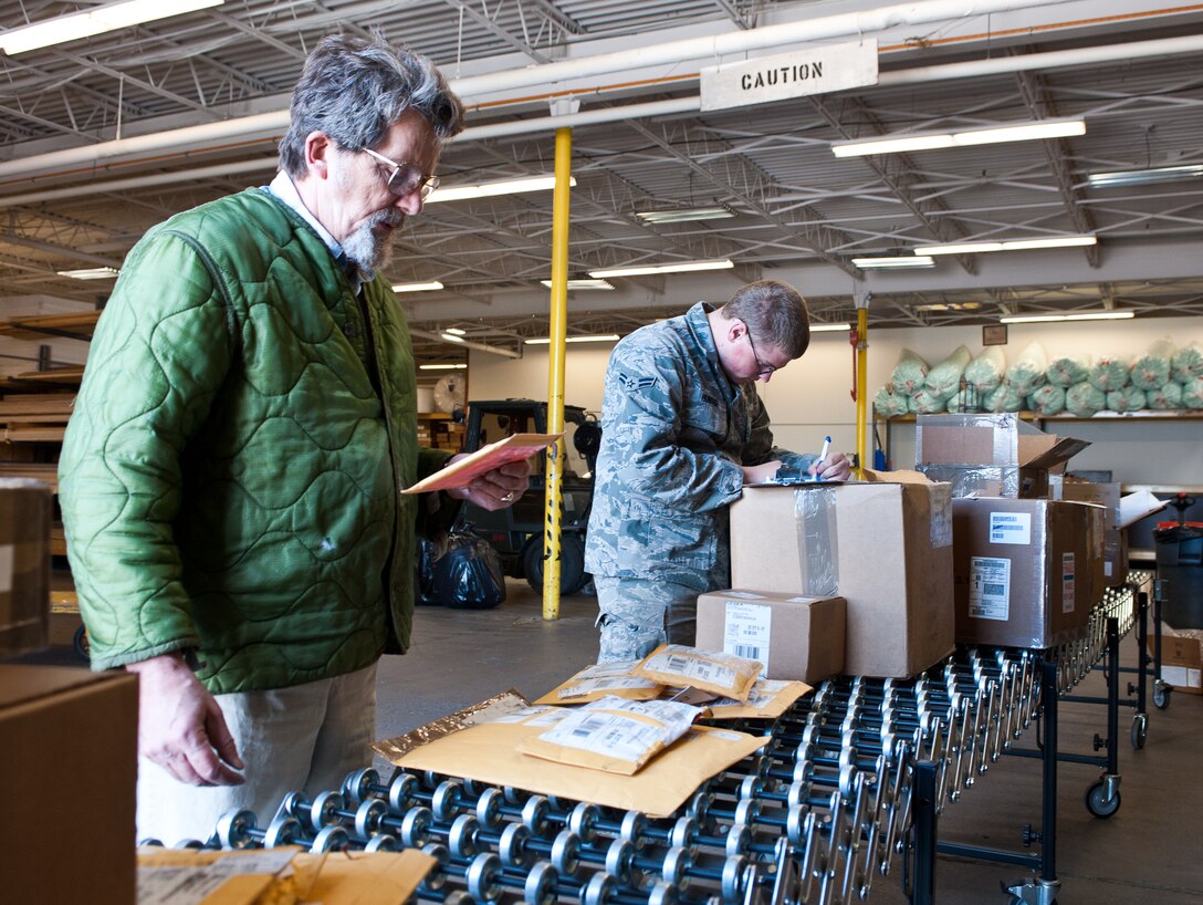 Paul Albrecht (left), 28th Logistics Readiness Squadron supply technician, reviews and reads off document and tracking numbers to Airman 1st Class Timothy Hunter, 28th LRS traffic management technician, during a delivery at Ellsworth Air Force Base, S.D., May 8, 2012. The numbers are tracked to the receiving system to ensure accountability of each item. (U.S. Air Force photo by Airman 1st Class Alystria Maurer/Released)