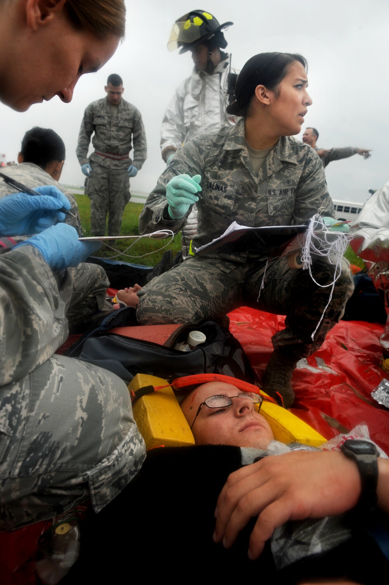 U.S. Air Force Airman 1st Class Alexa Salinas, 18th Medical Group and firefighters from the 18th Civil Engineer Squadron treat simulated wounded personnel during an emergency management exercise (EME) taking place during local operational readiness exercise Beverly High 12-4 on Kadena Air Base, Japan, May 16, 2012. Evaluations like this EME will be taking place all week to test the skills and knowledge of Kadena’s Airmen to ensure they are ready to respond to contingencies throughout the Pacific command. (U.S Air Force photo/Staff Sgt. Laszlo Babocsi)